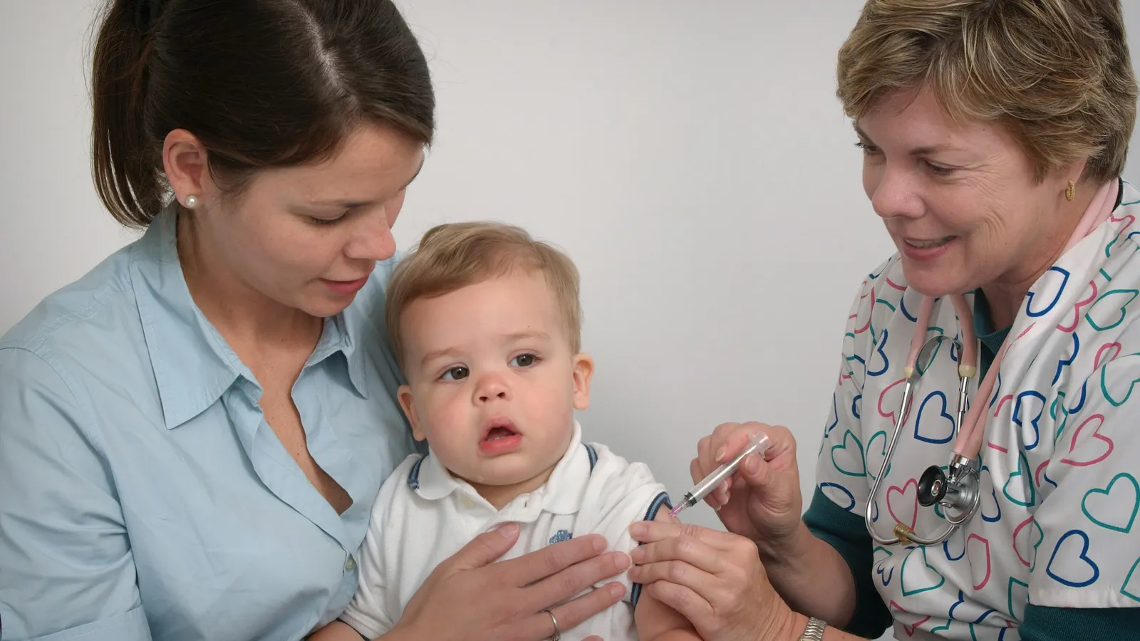 A baby on a parent's lap at a vaccination visit