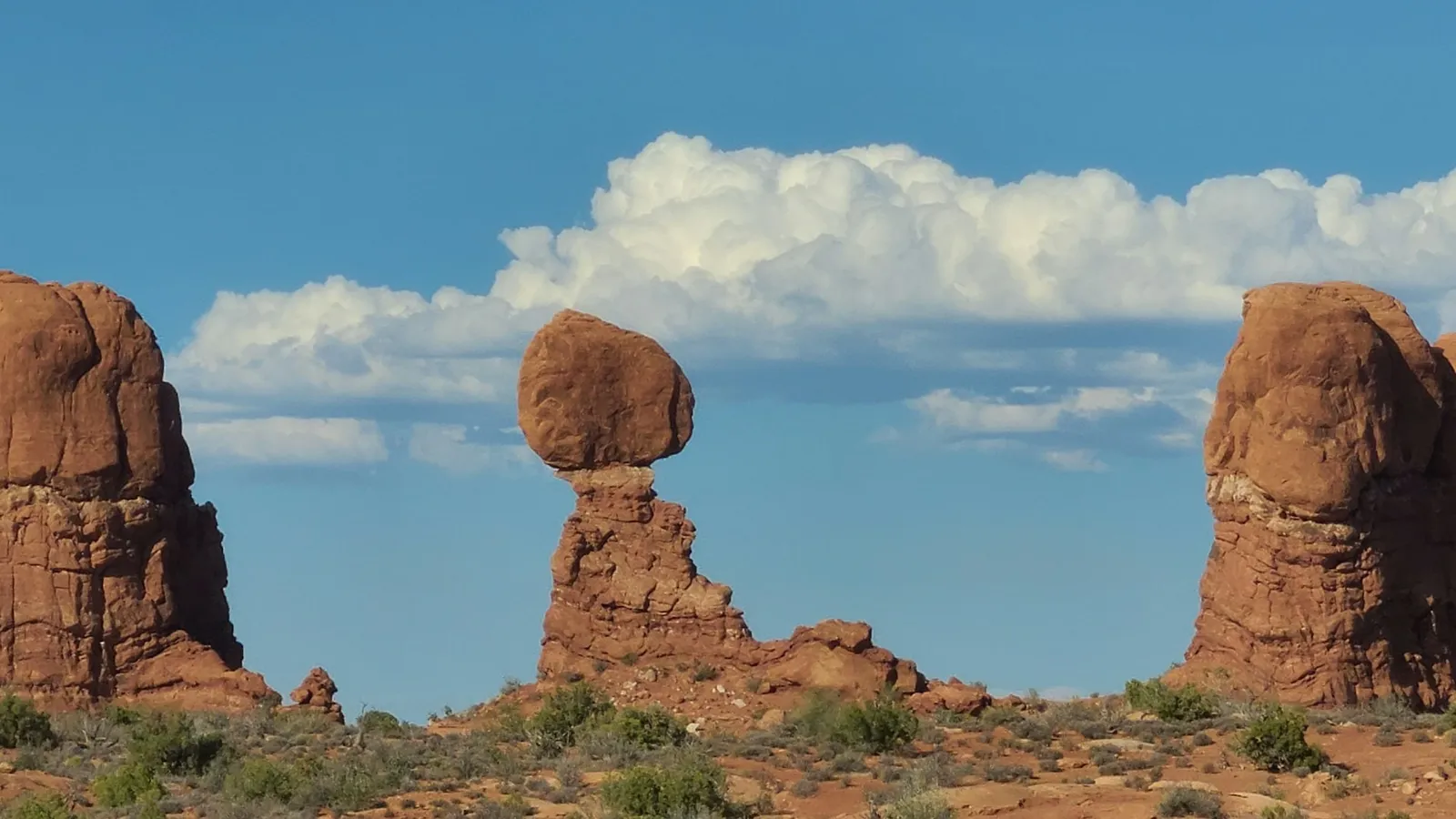 A balanced rock perched on a narrow pillar in the desert