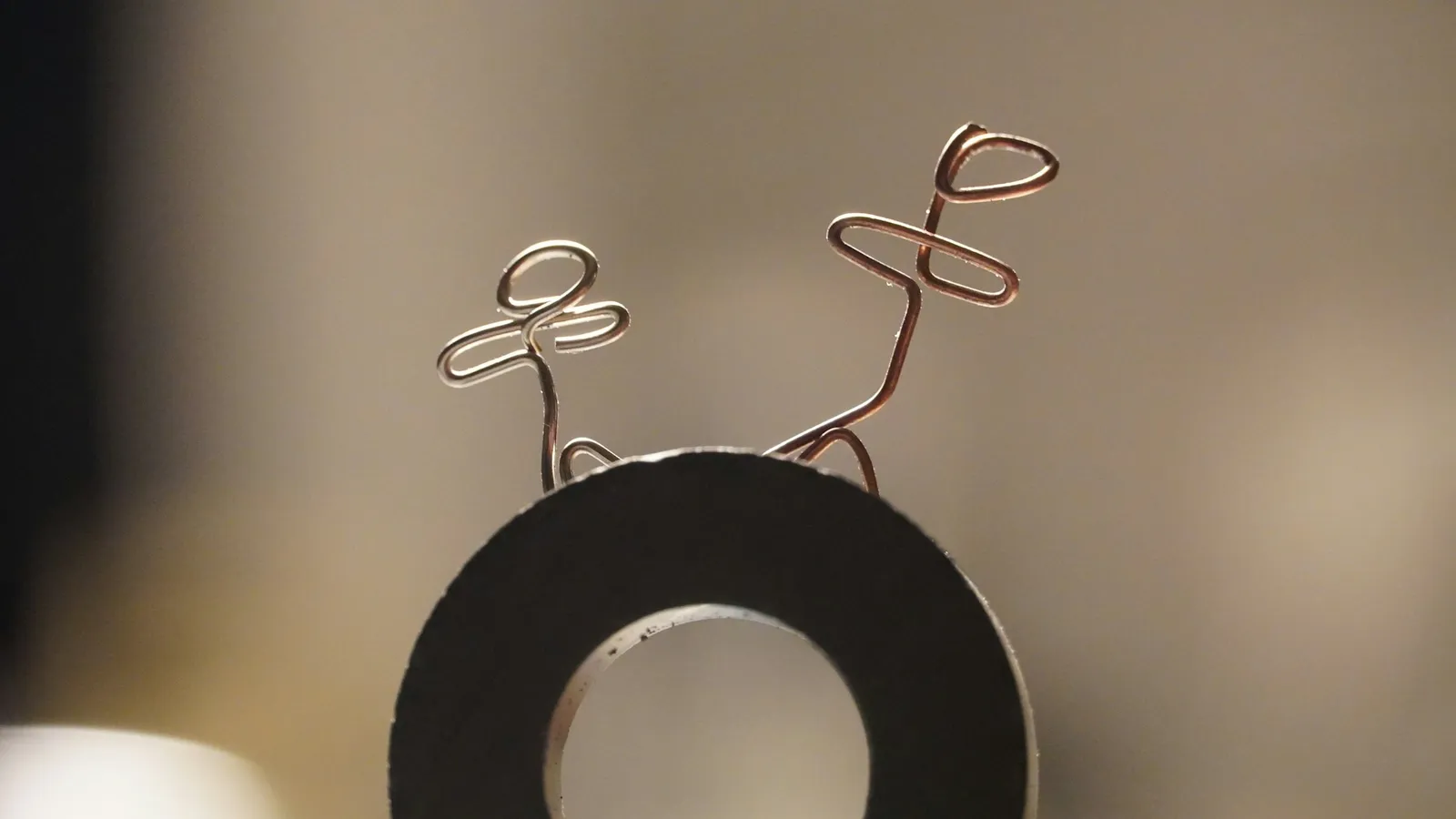 A bent wire loop beside a ring magnet