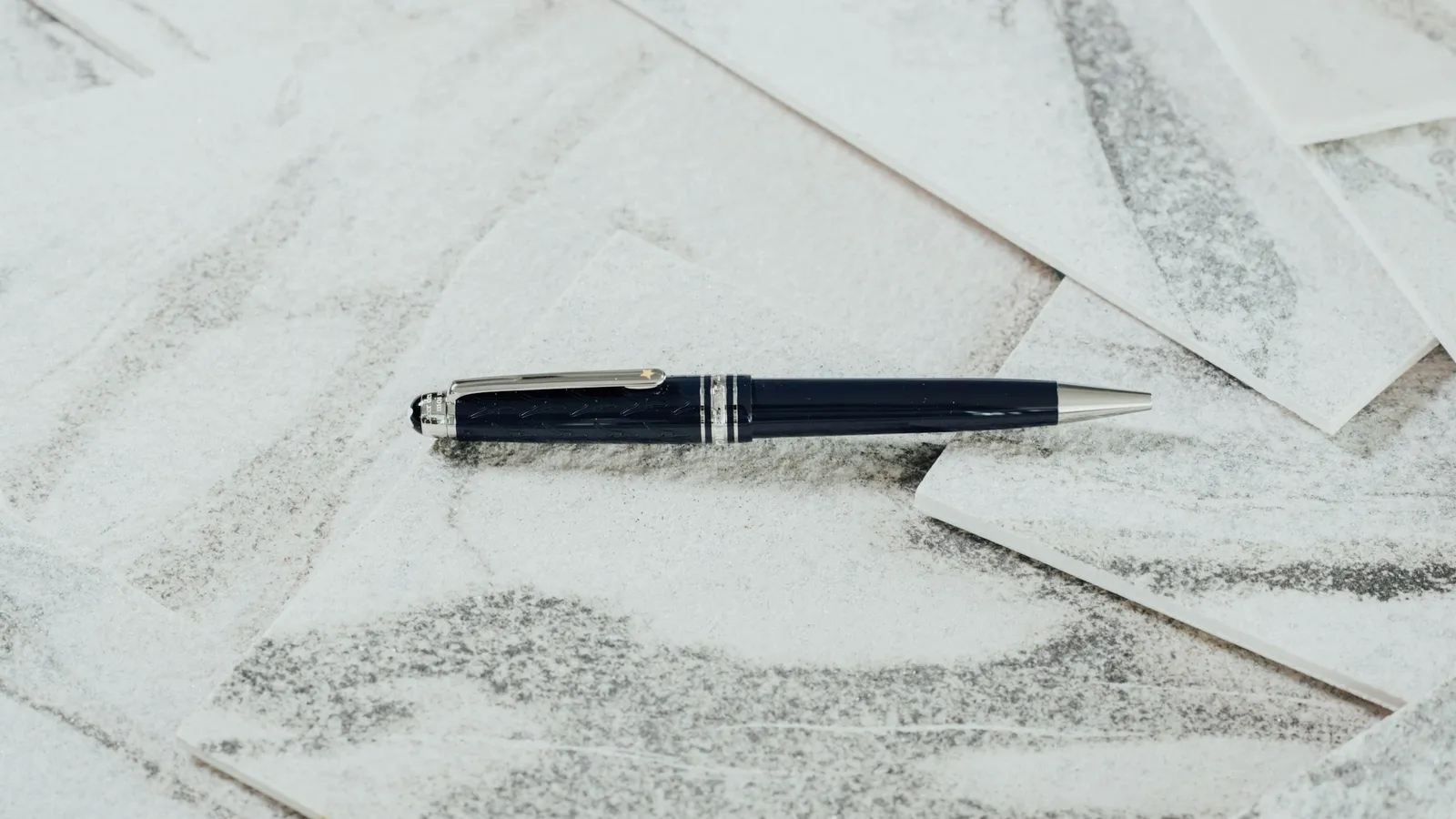 A black pen resting on sheets of white paper