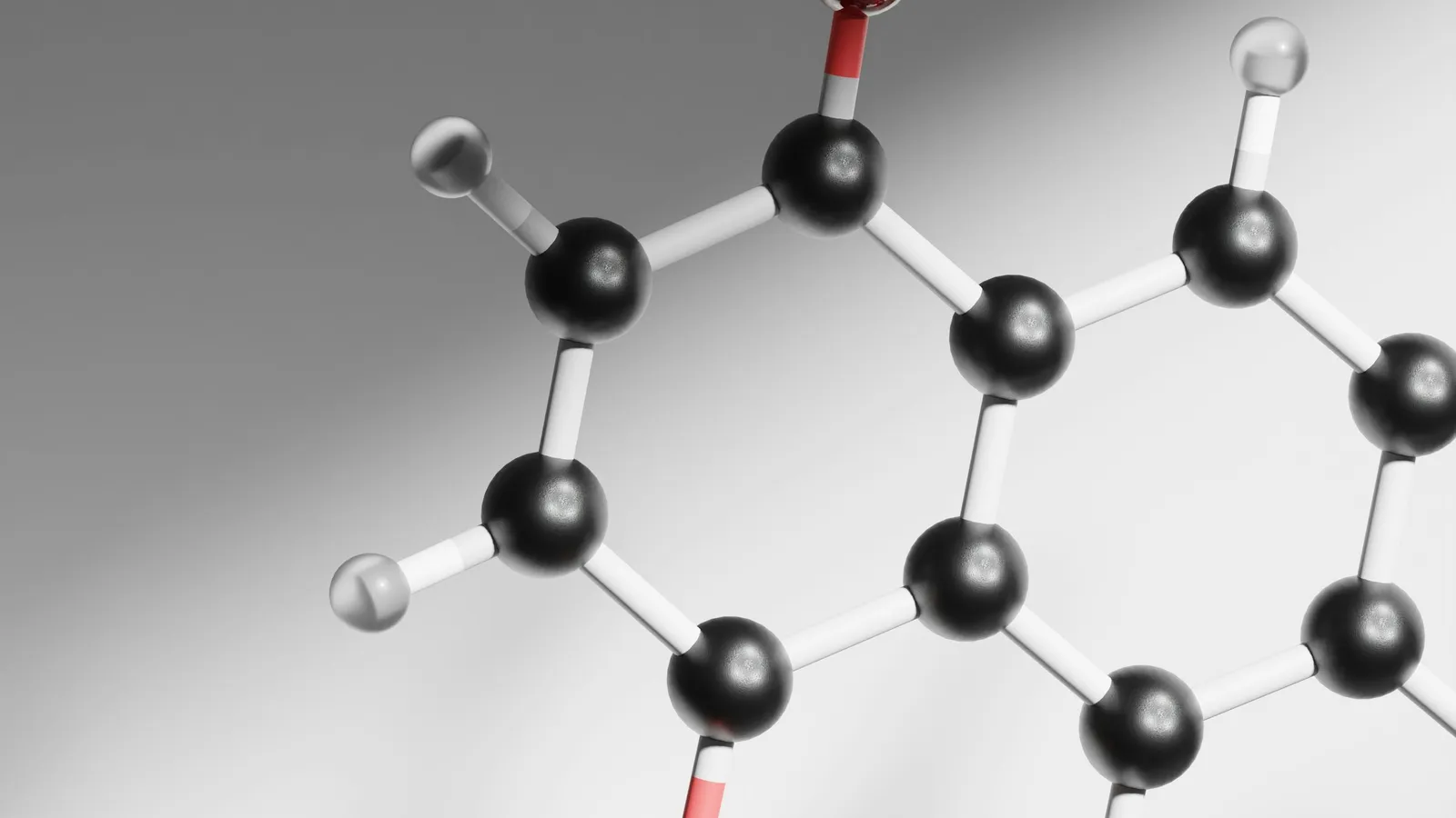 A black, white and red ball-and-stick model of a ring-shaped molecule