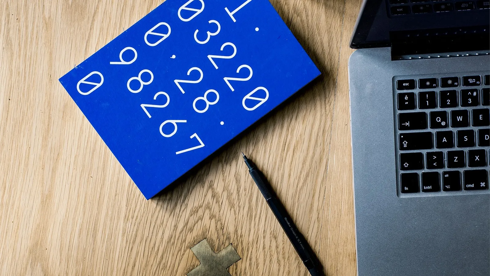 A blue card printed with rows of numbers beside a laptop