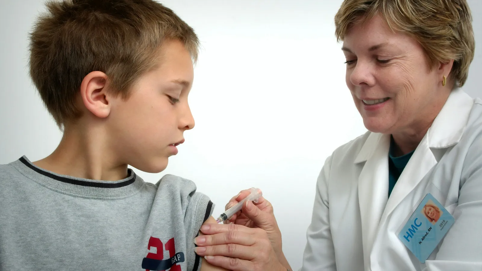 A boy getting a vaccine from a doctor