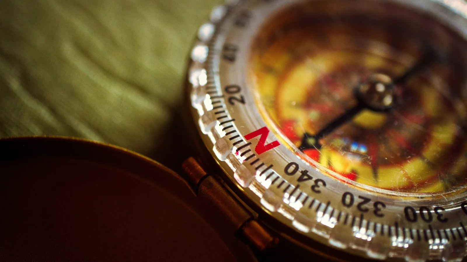A brass compass with its needle pointing north