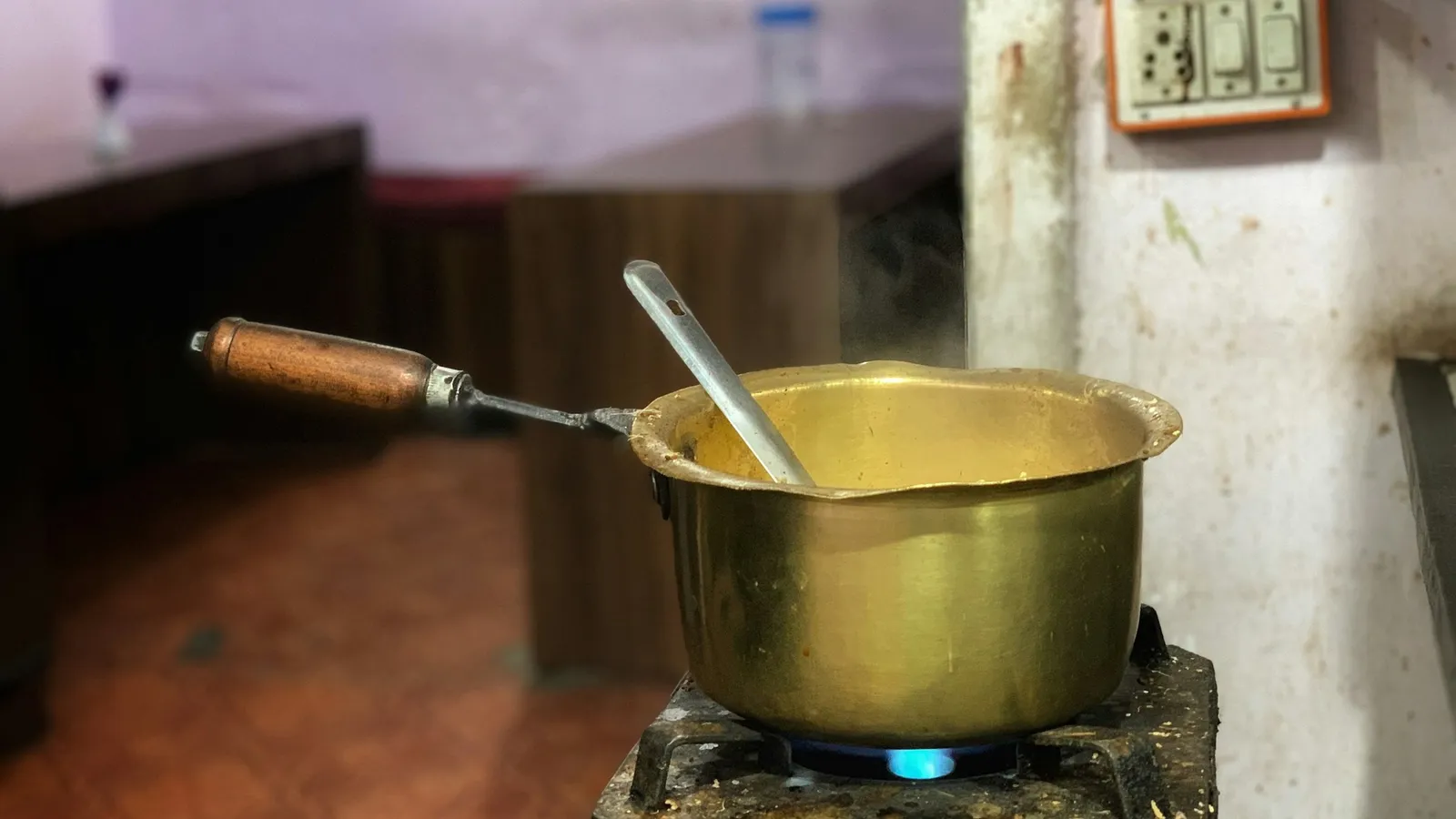 A brass cooking pot on a simple kitchen surface