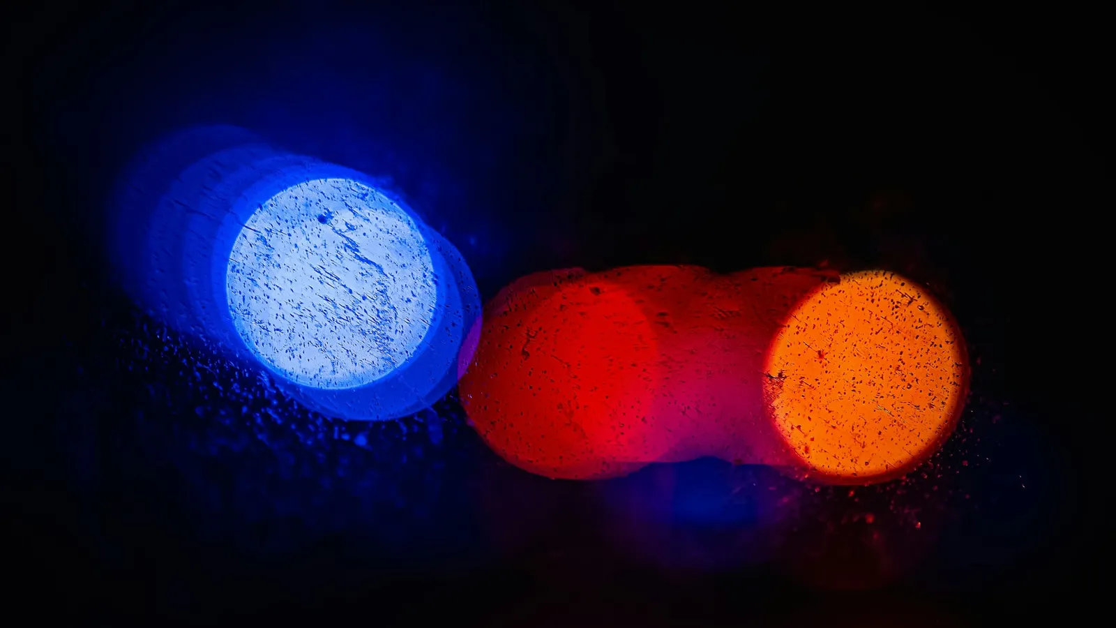 A bright blue glow beside orange lights in the dark