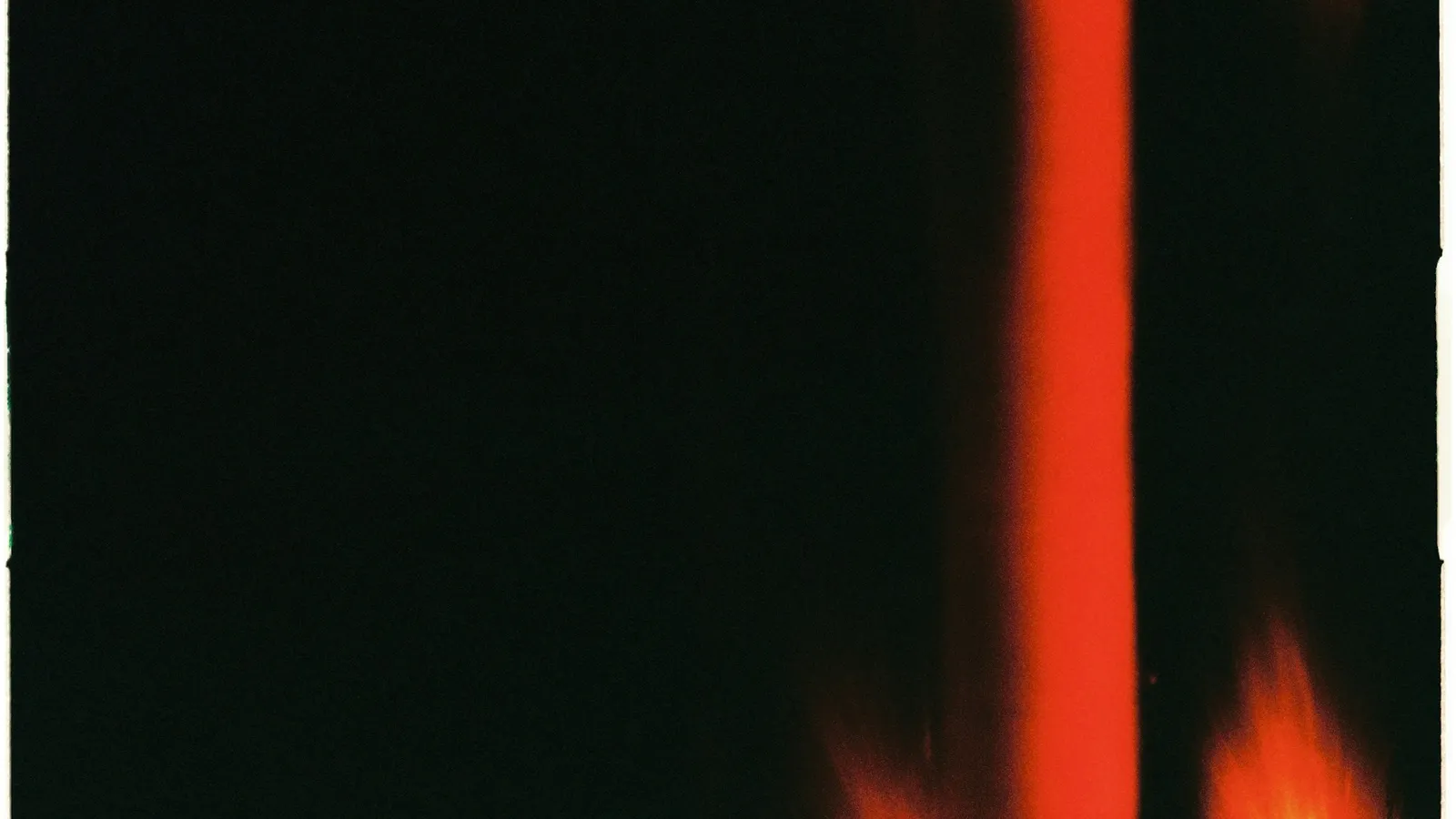 A bright red flame against a dark background