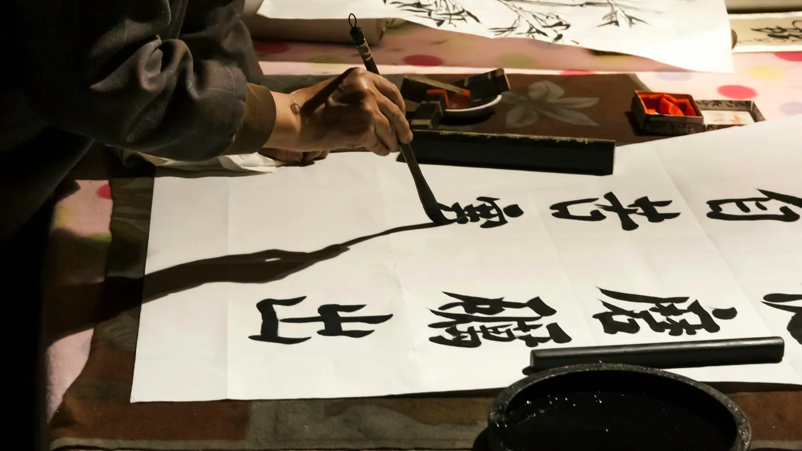 A brush writing Chinese characters on paper