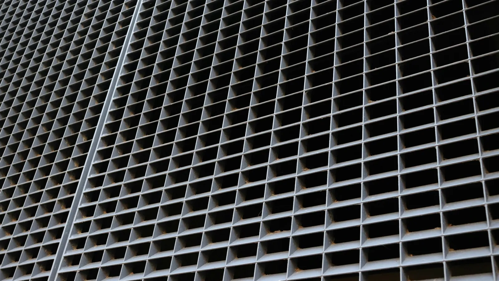 A building facade of identical square windows in rows