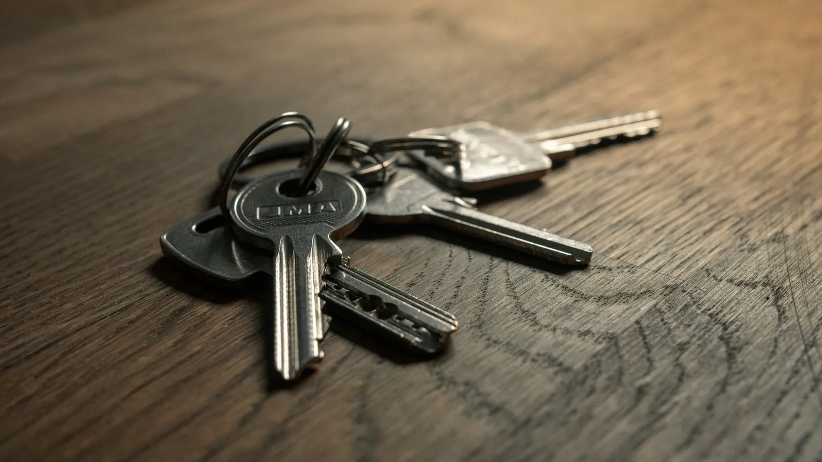 A bunch of keys lying on a wooden table