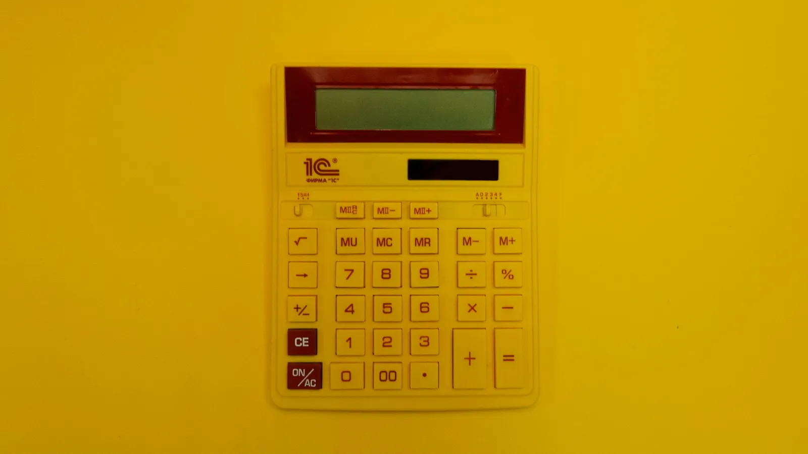A calculator on a bright yellow background