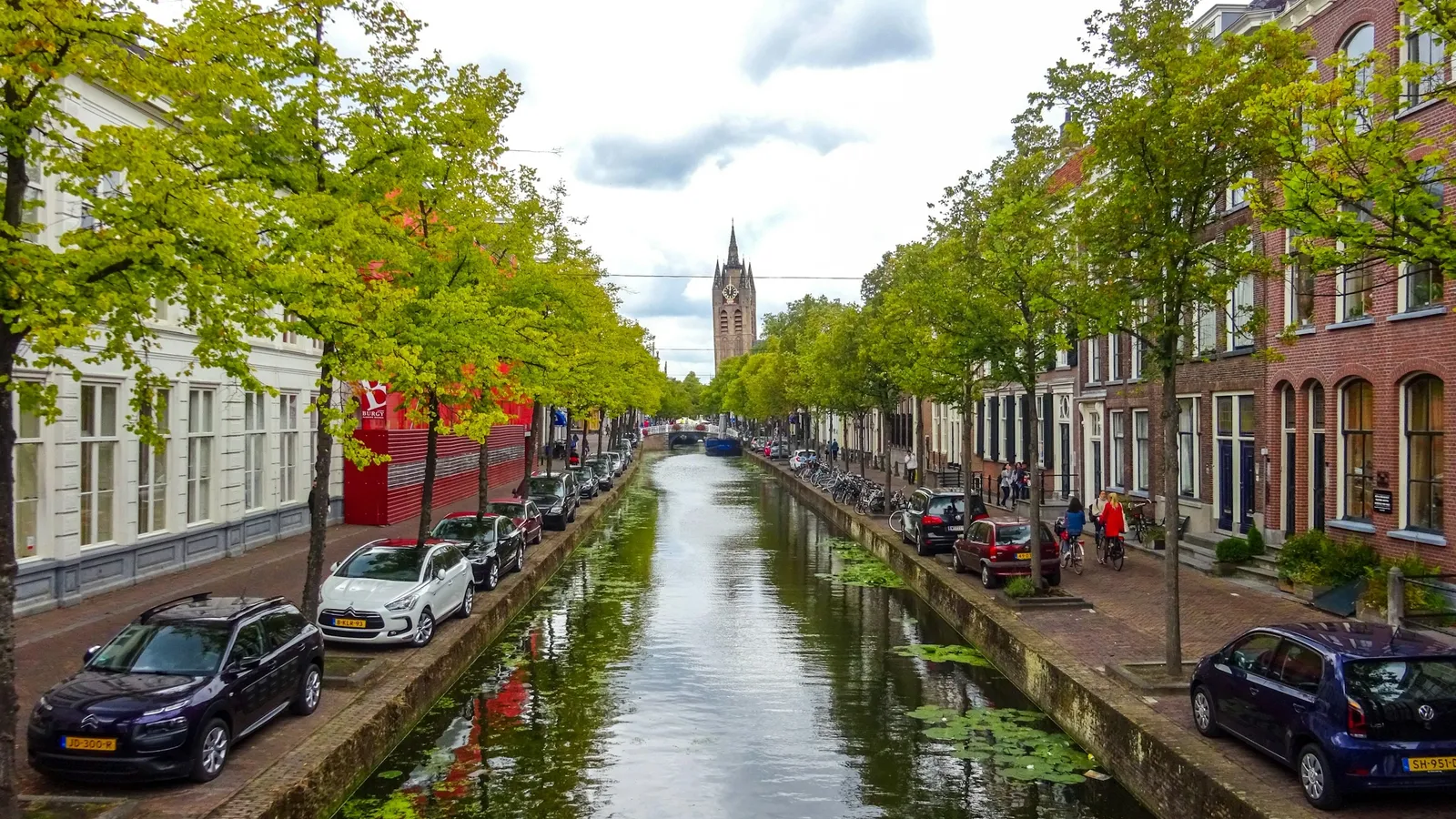 A canal lined with trees and brick houses in a Dutch town