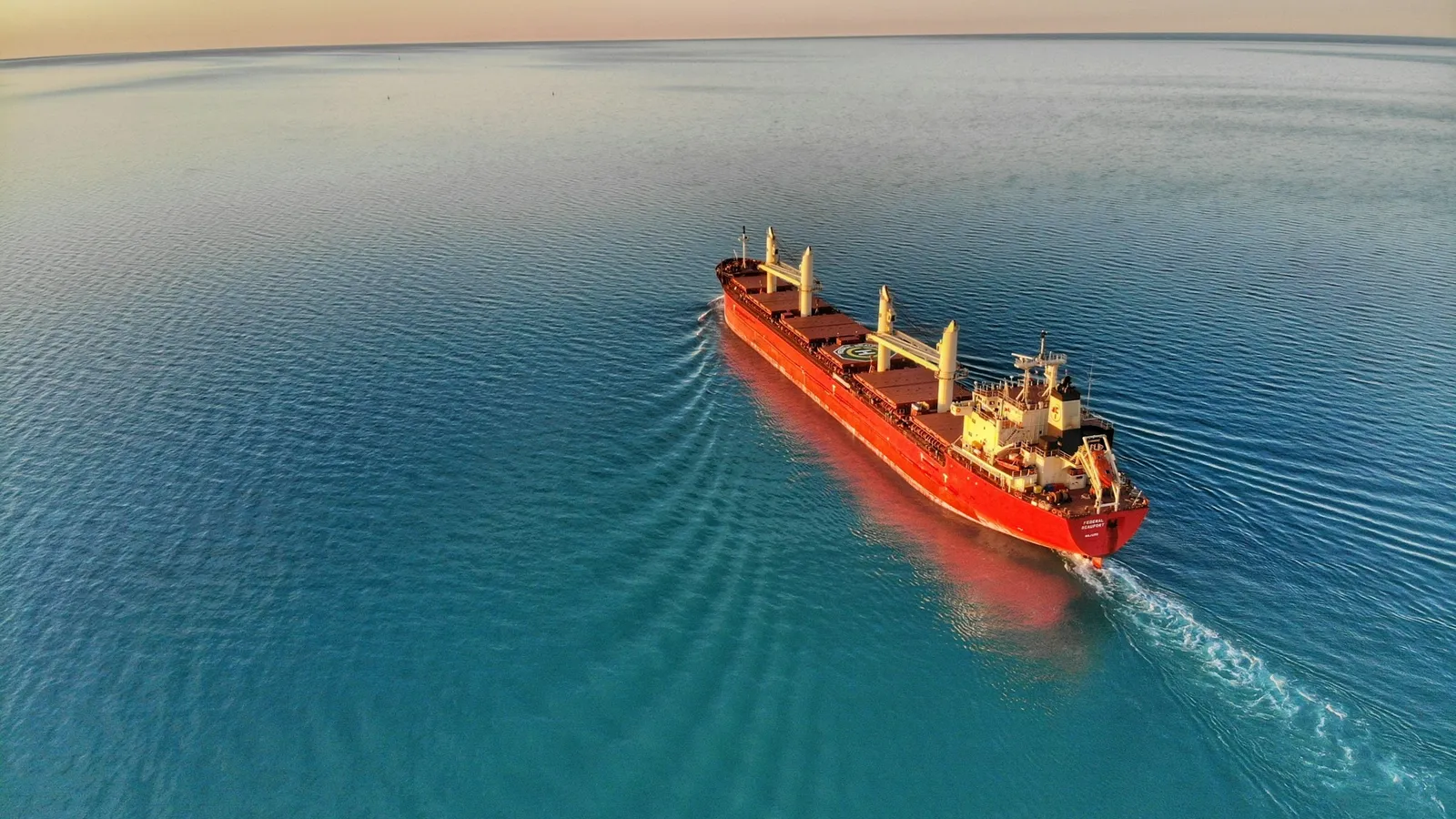 A cargo ship crossing the open ocean seen from above