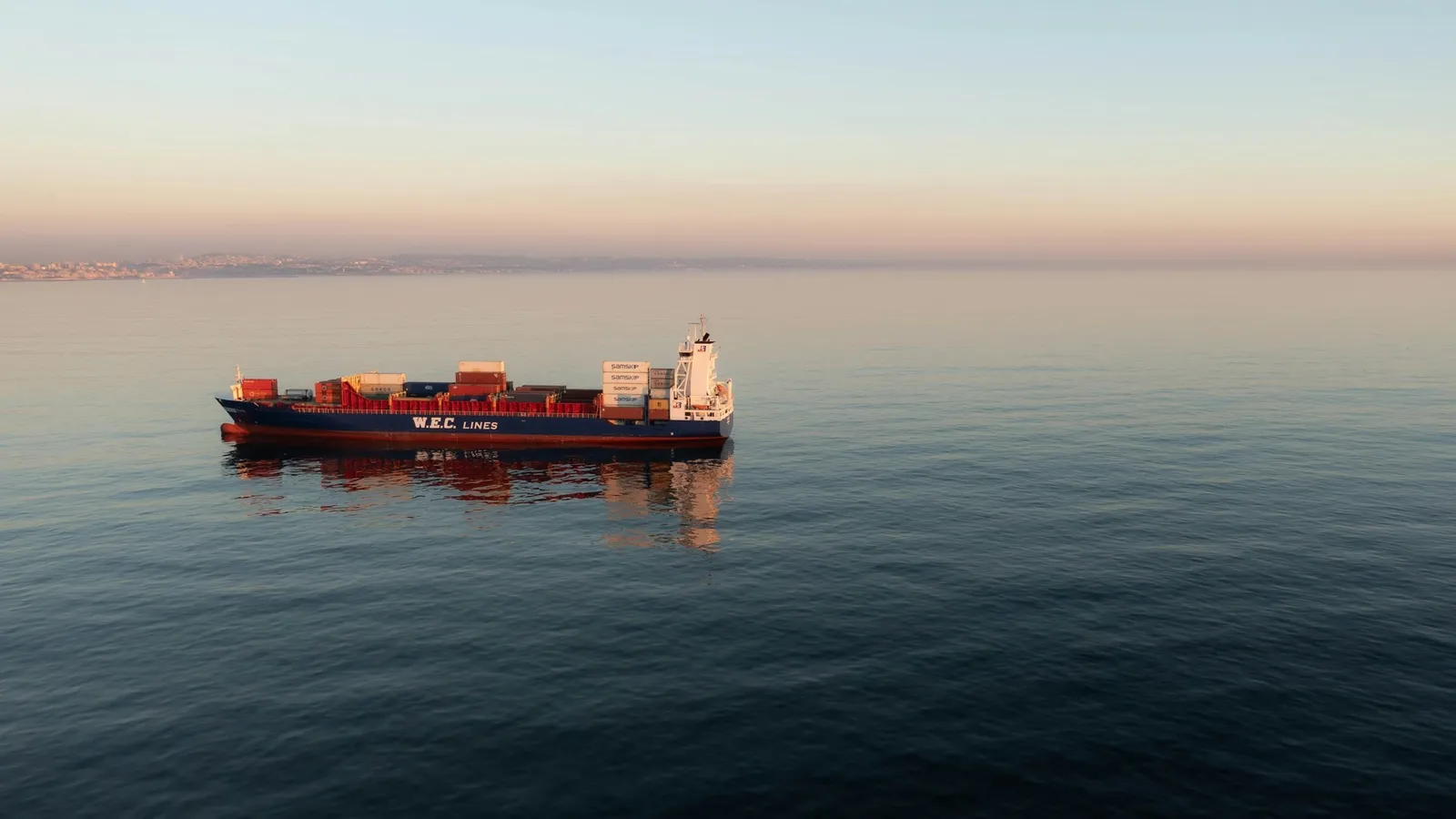 A cargo ship on calm sea at sunset
