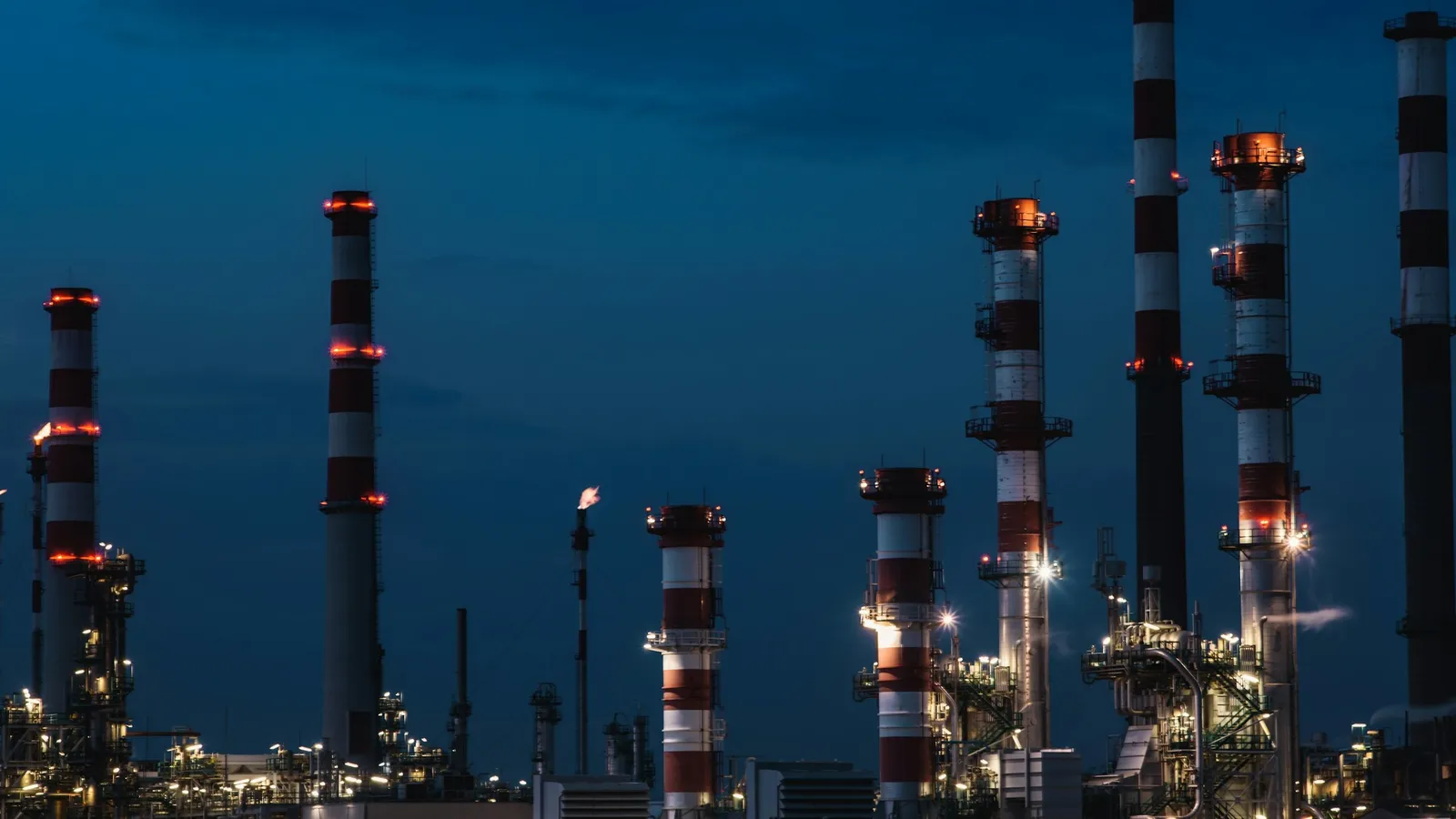 A chemical plant lit up at dusk