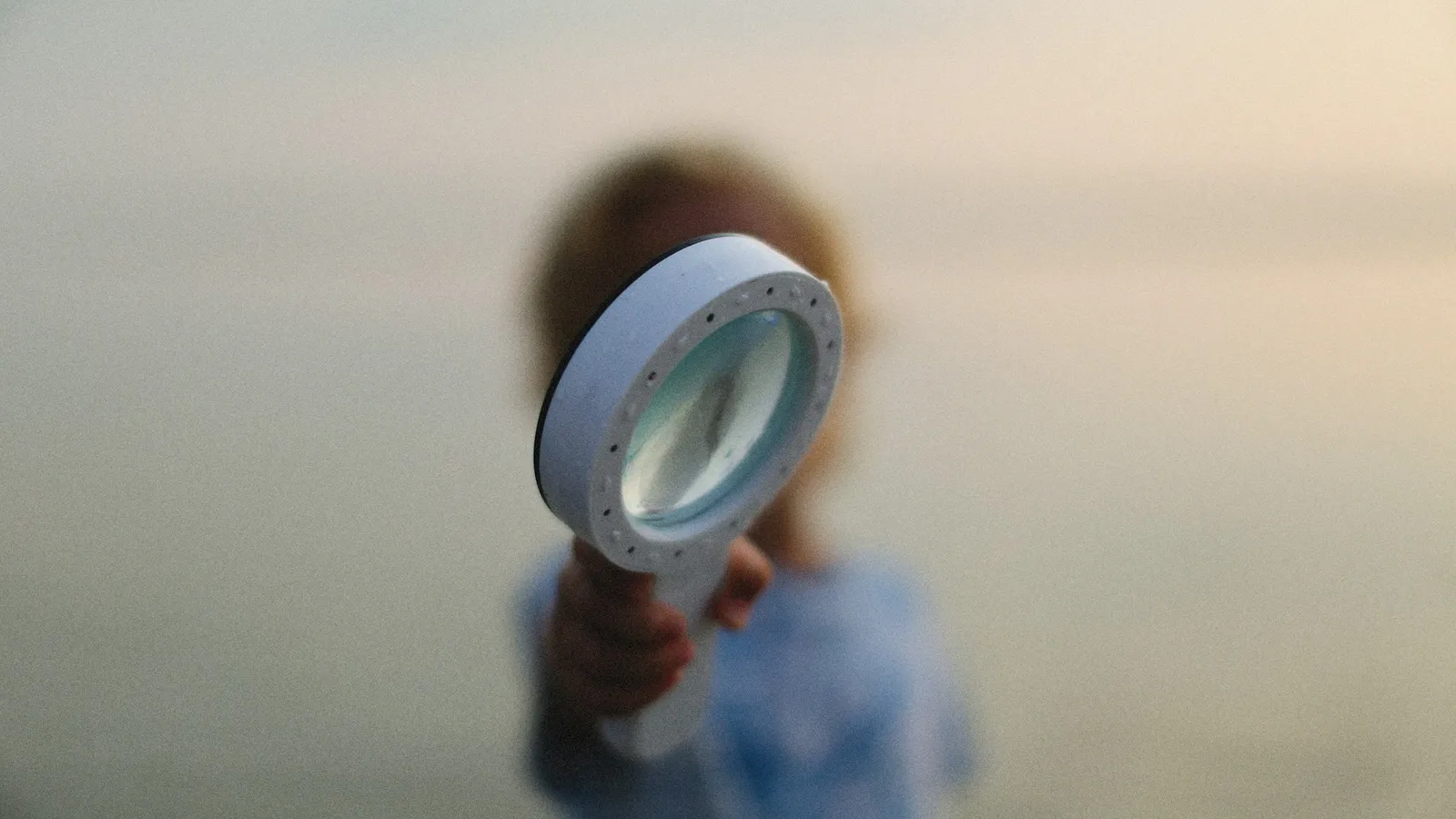 A child looking through a magnifying glass