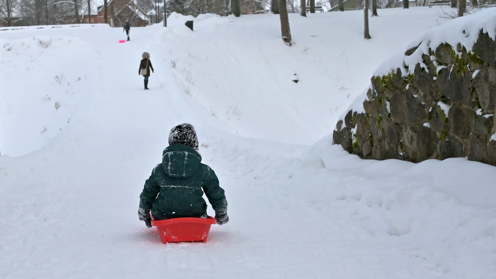 A child pulling a sled through snow