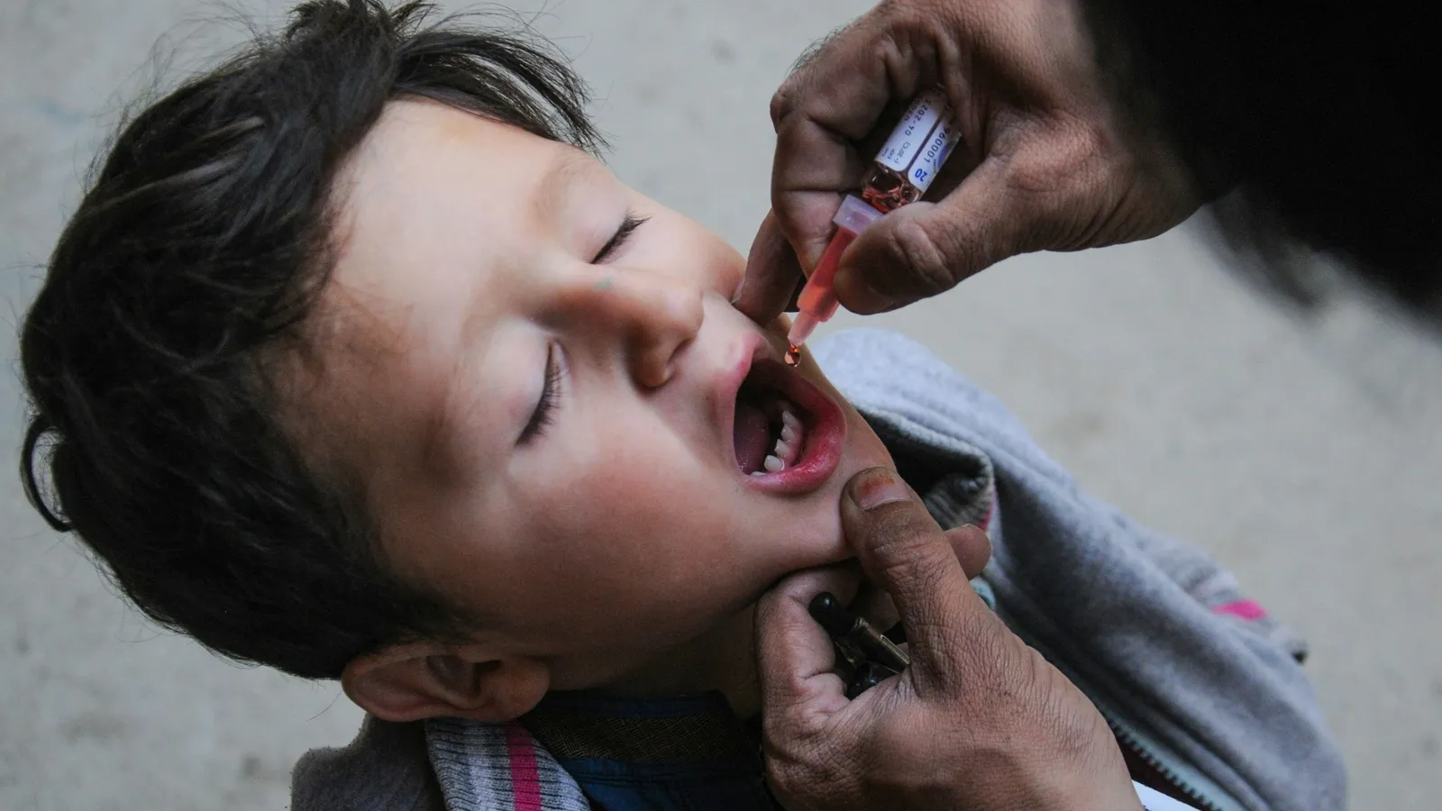 A child receiving oral vaccine drops