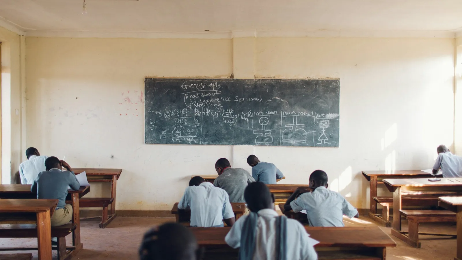 A classroom of students facing a blackboard