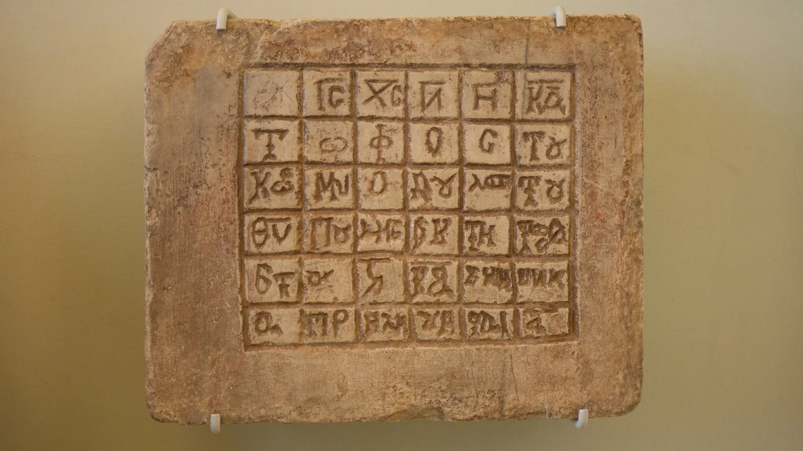 A clay tablet carved with a grid of symbols