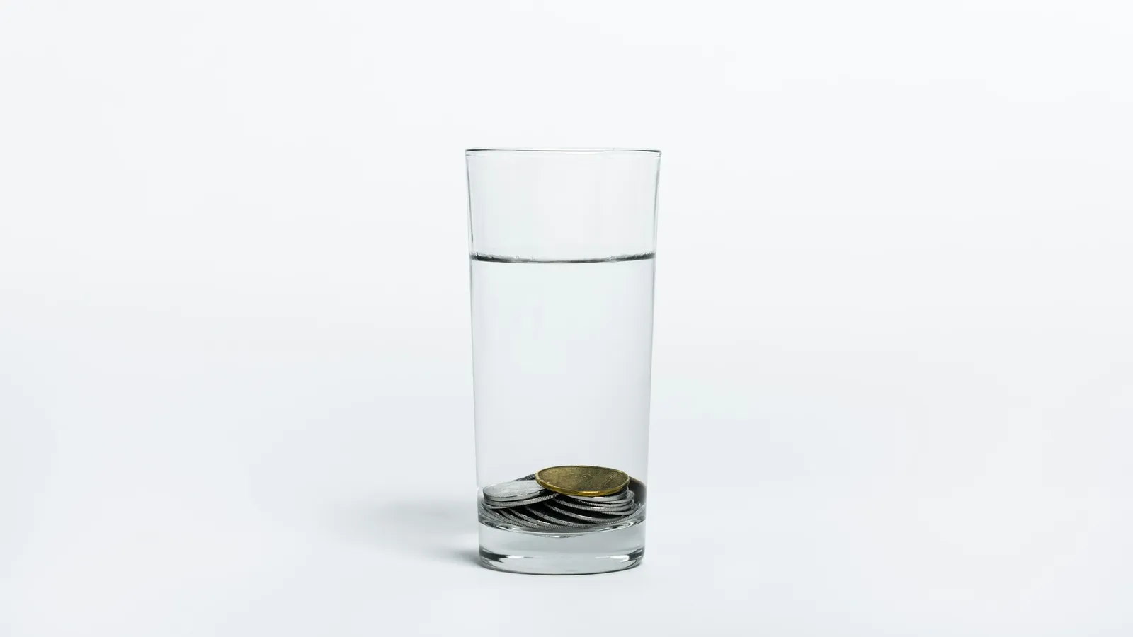 A coin lying at the bottom of a glass of water
