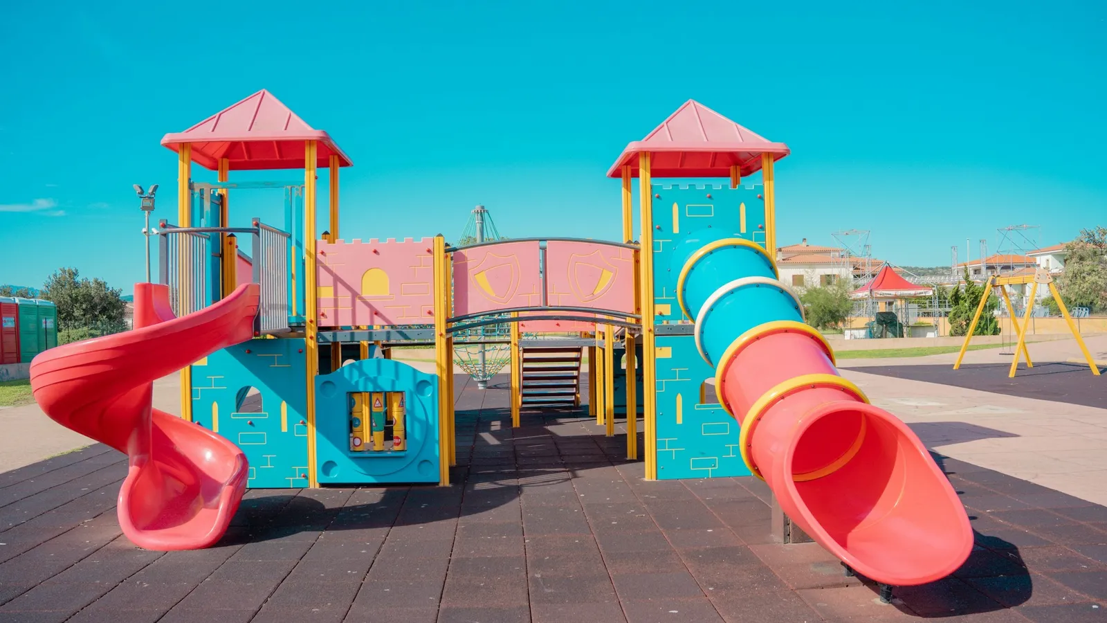A colourful playground slide and climbing frame