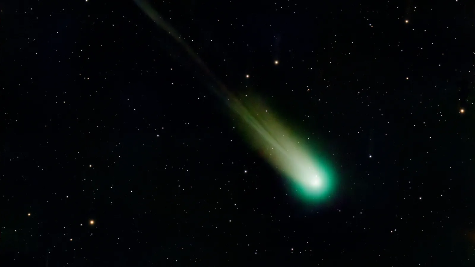 A comet with a glowing tail among stars
