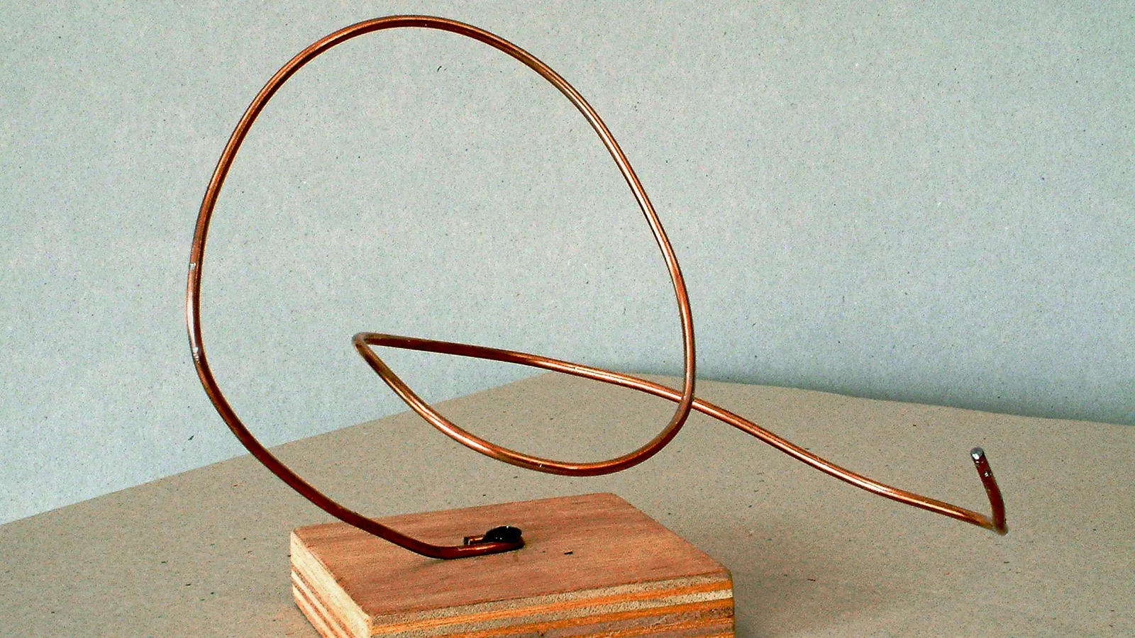 A copper wire bent into a loop on a wooden stand