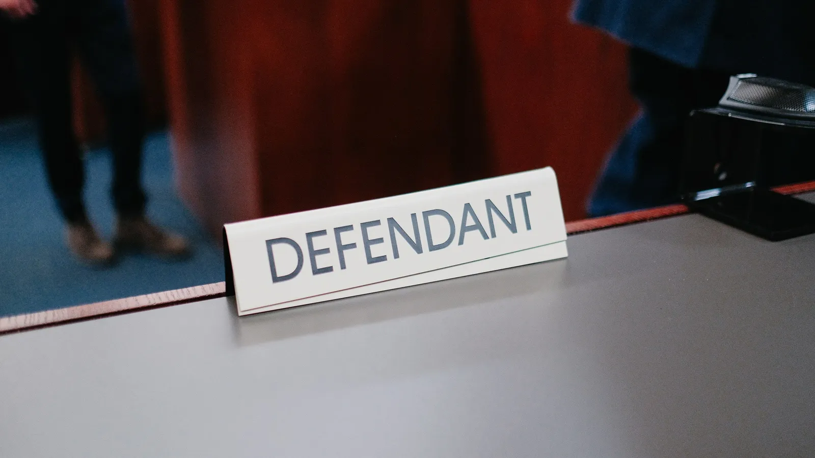 A courtroom table with a sign reading defendant