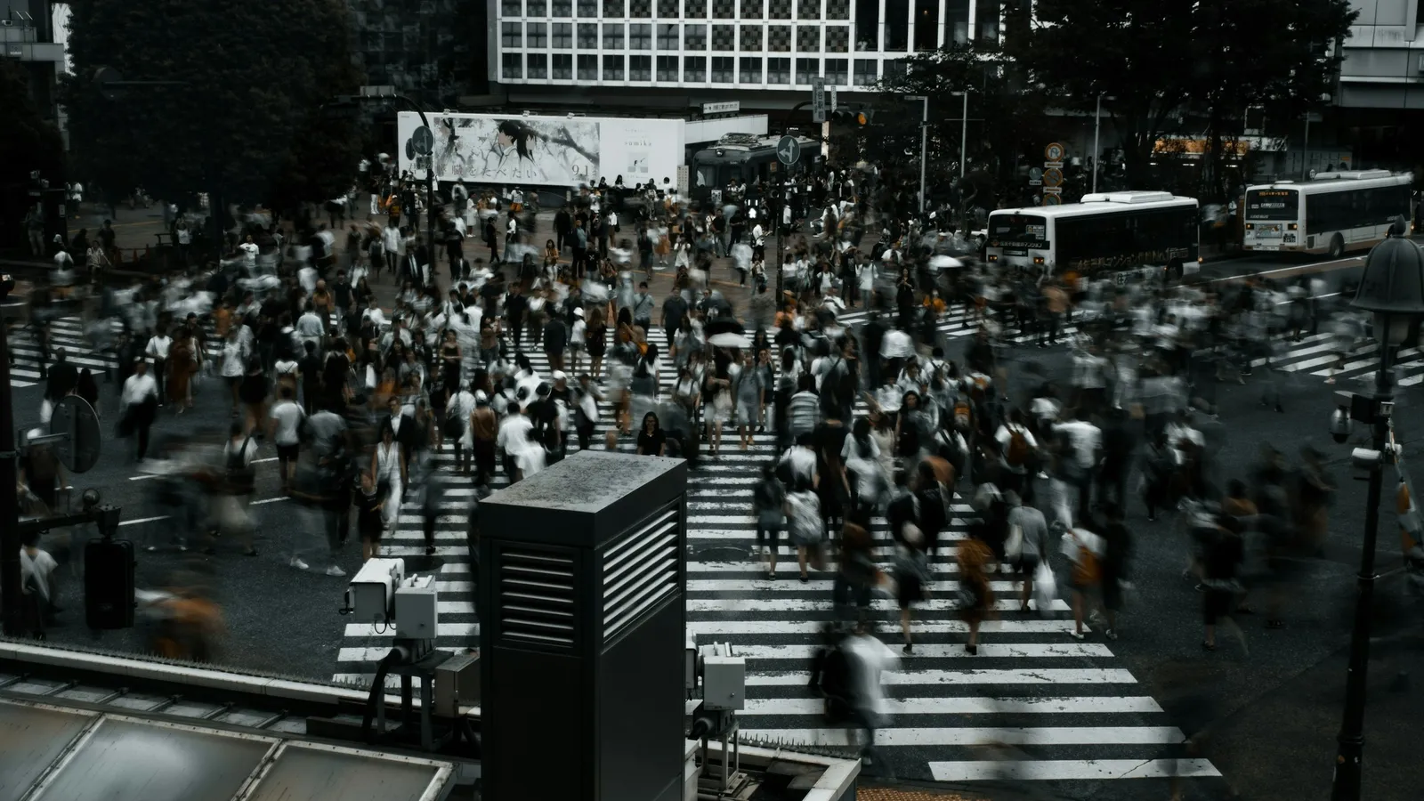 A crowd of people crossing a busy city street