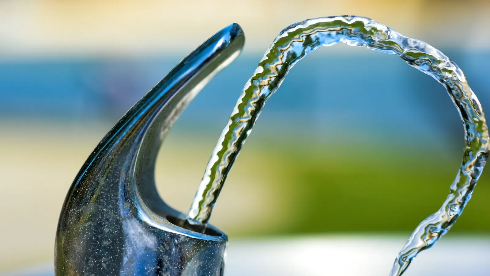 A curved arc of water from a fountain spout