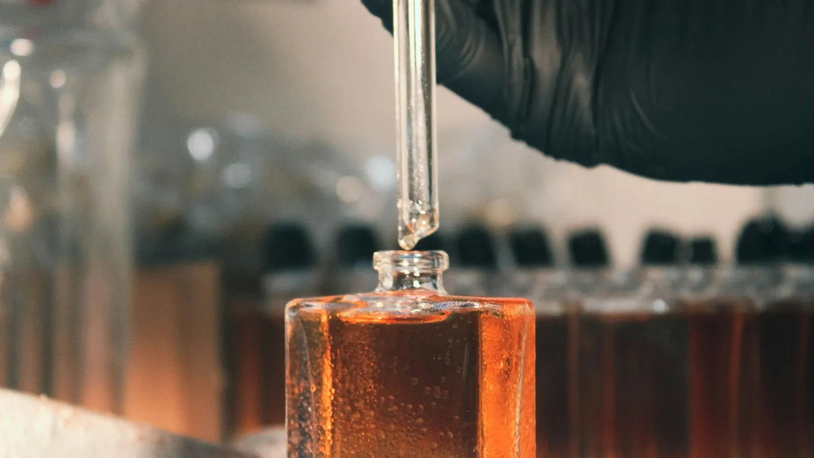 A dropper adding liquid to an orange solution