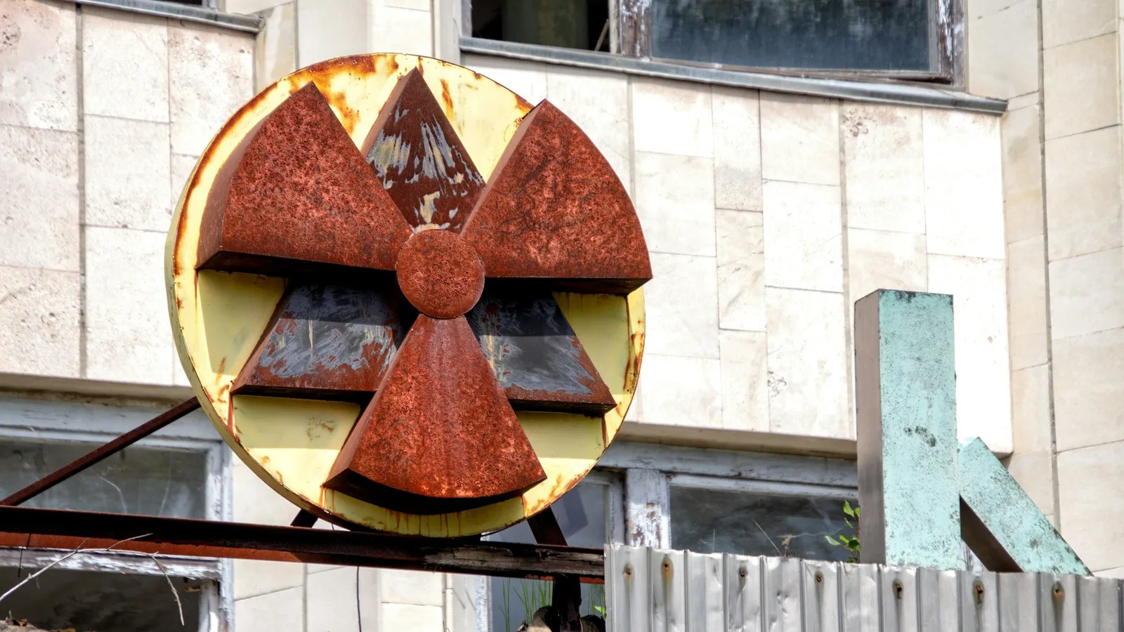 A faded radiation warning symbol on an old building