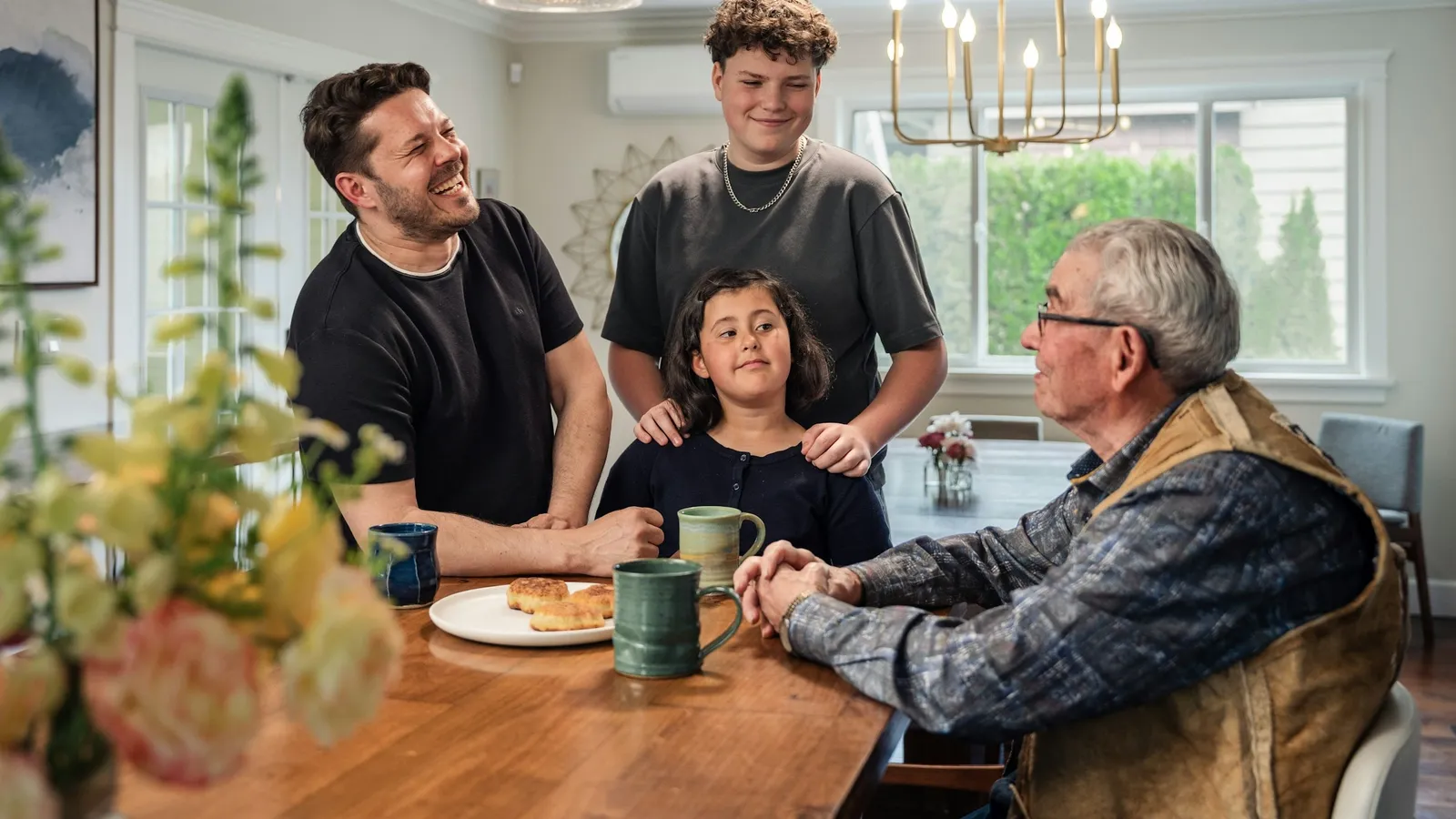 A family of four talking around a wooden dining table