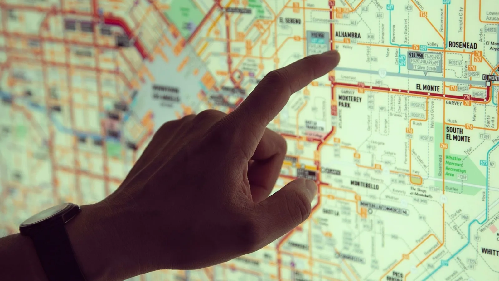 A finger tracing a route on a city transit map