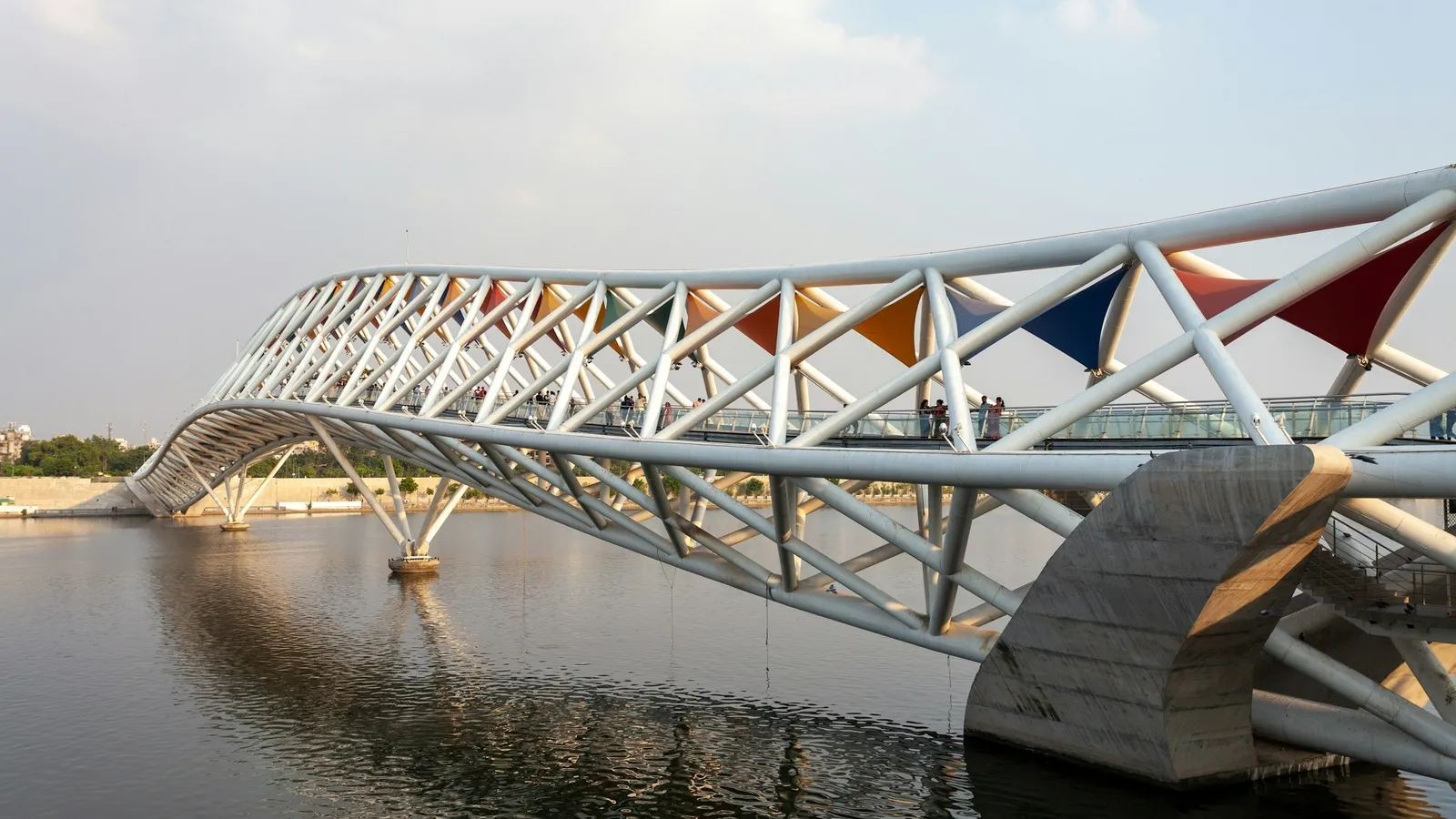 A footbridge with a patterned roof over the Sabarmati river in Ahmedabad
