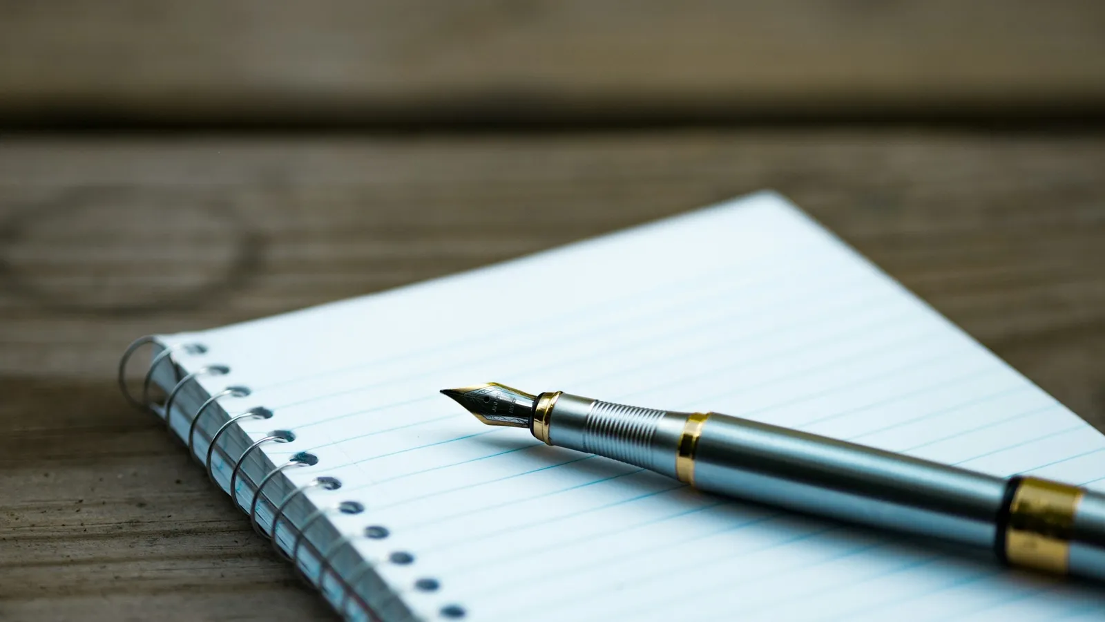 A fountain pen resting on a notepad