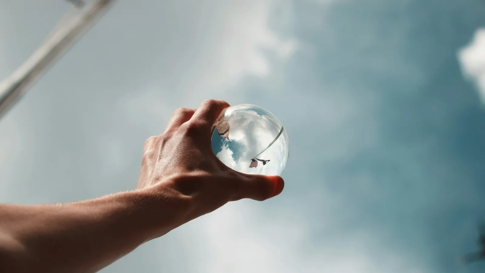 A glass ball held up against the sky showing an inverted view