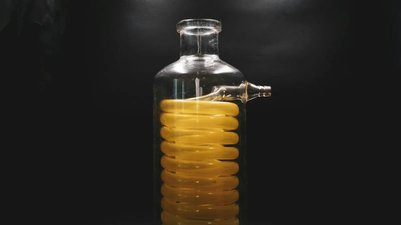 A glass condenser filled with amber liquid
