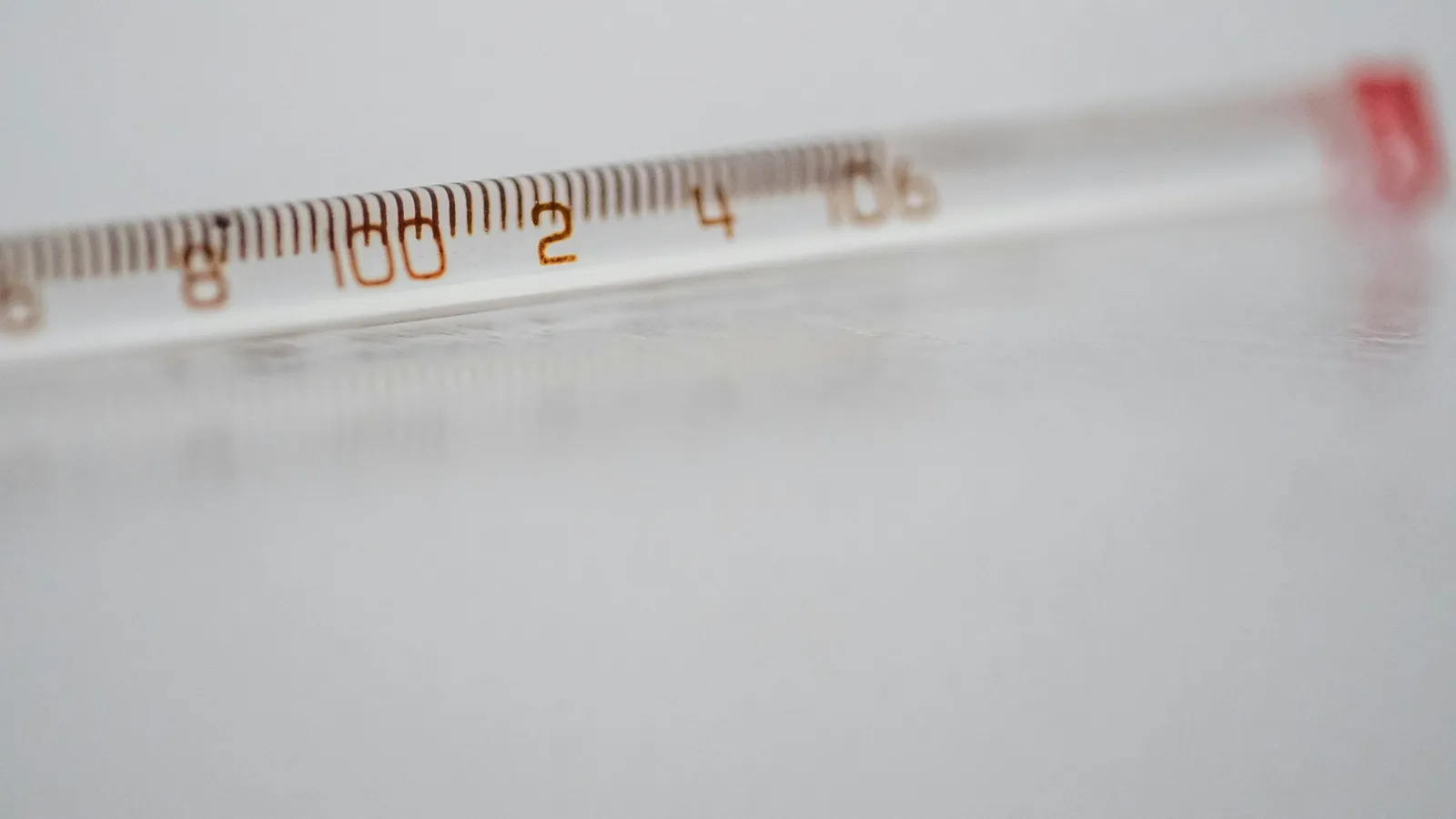 A glass laboratory thermometer with a printed scale