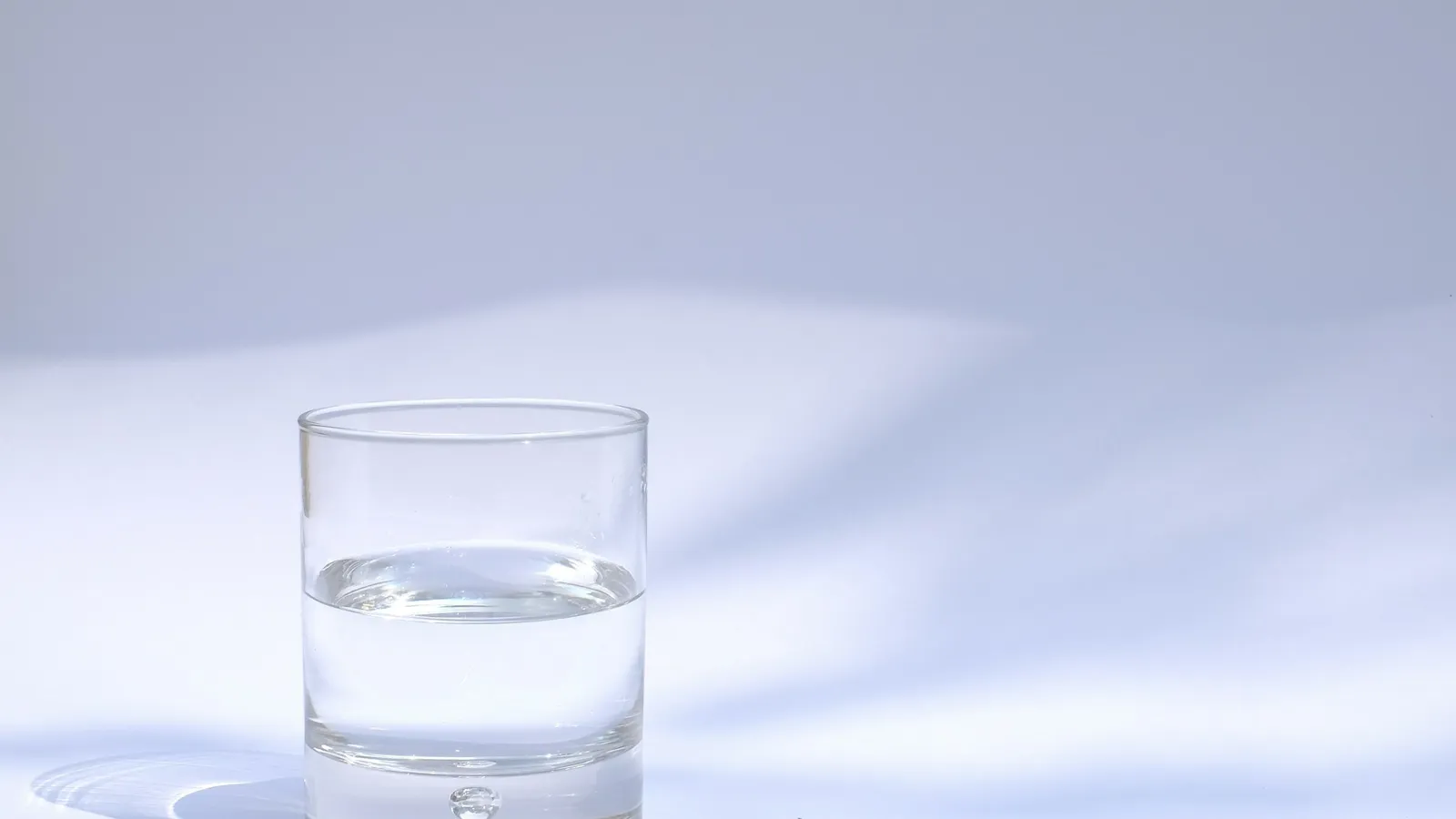 A glass of clean water on a pale table