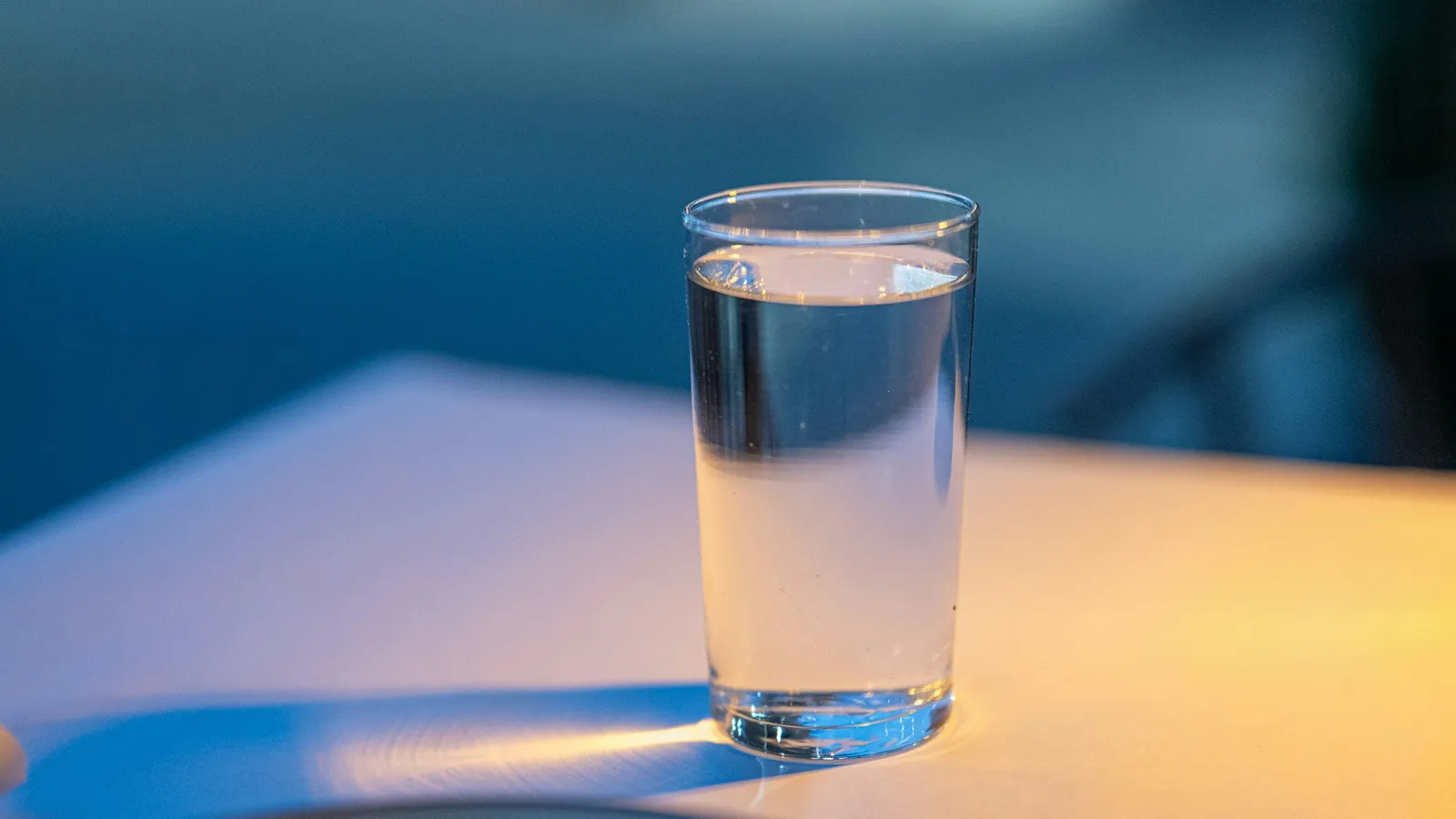 A glass of water bending the light on a table