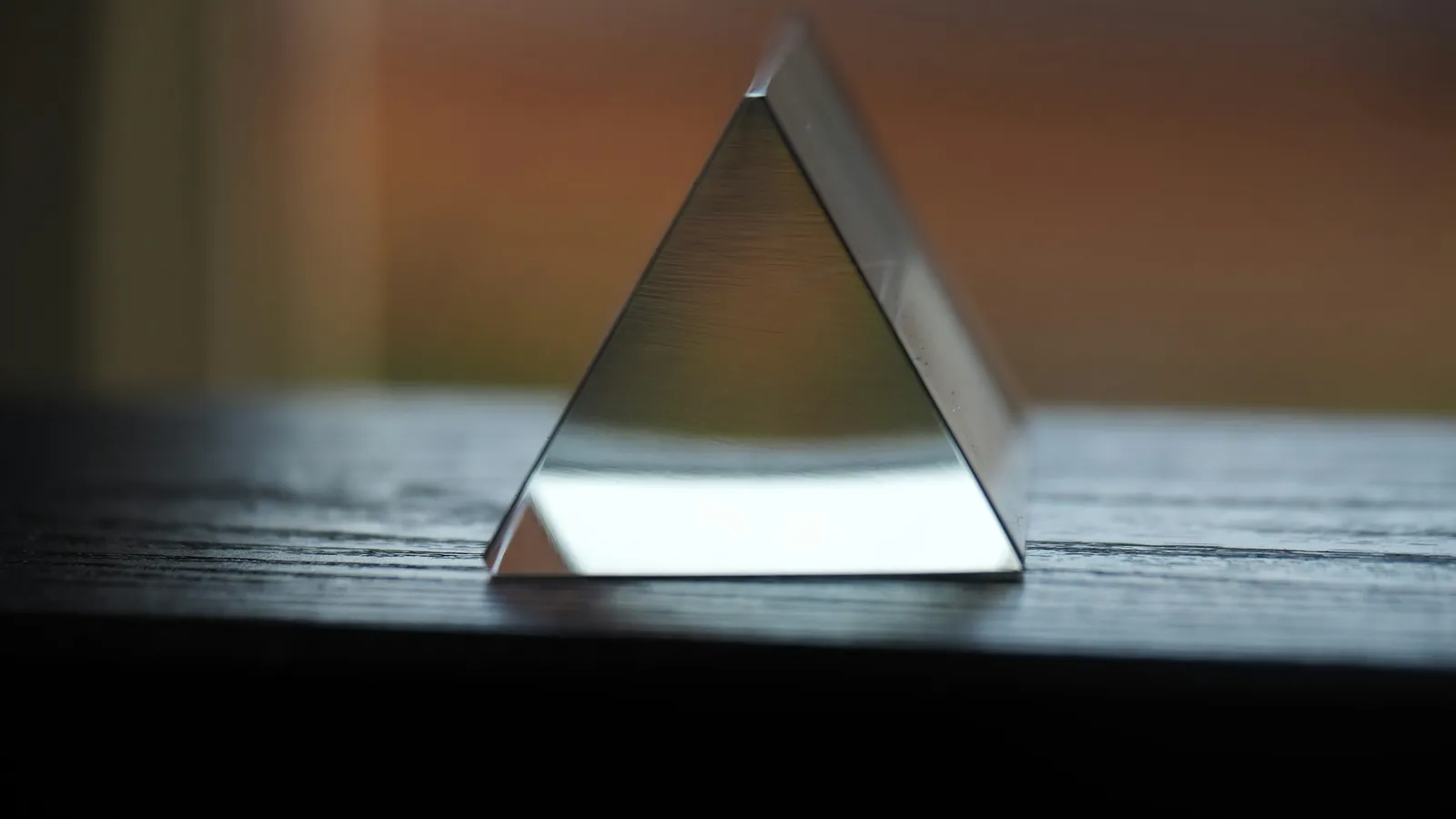 A glass triangular prism on a table