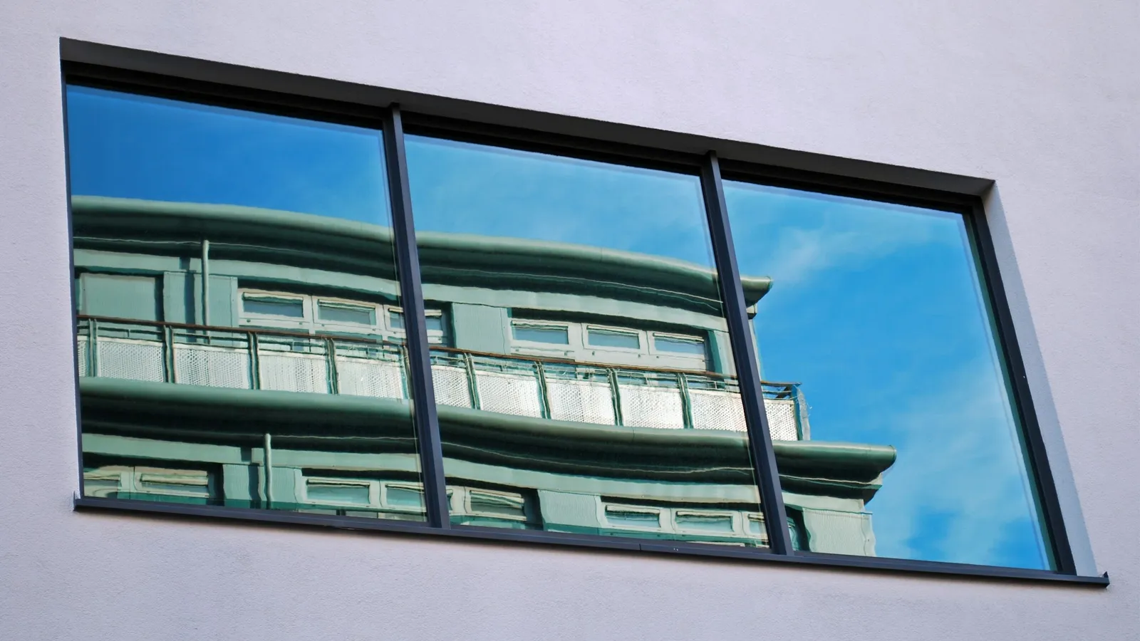 A glass window reflecting the sky