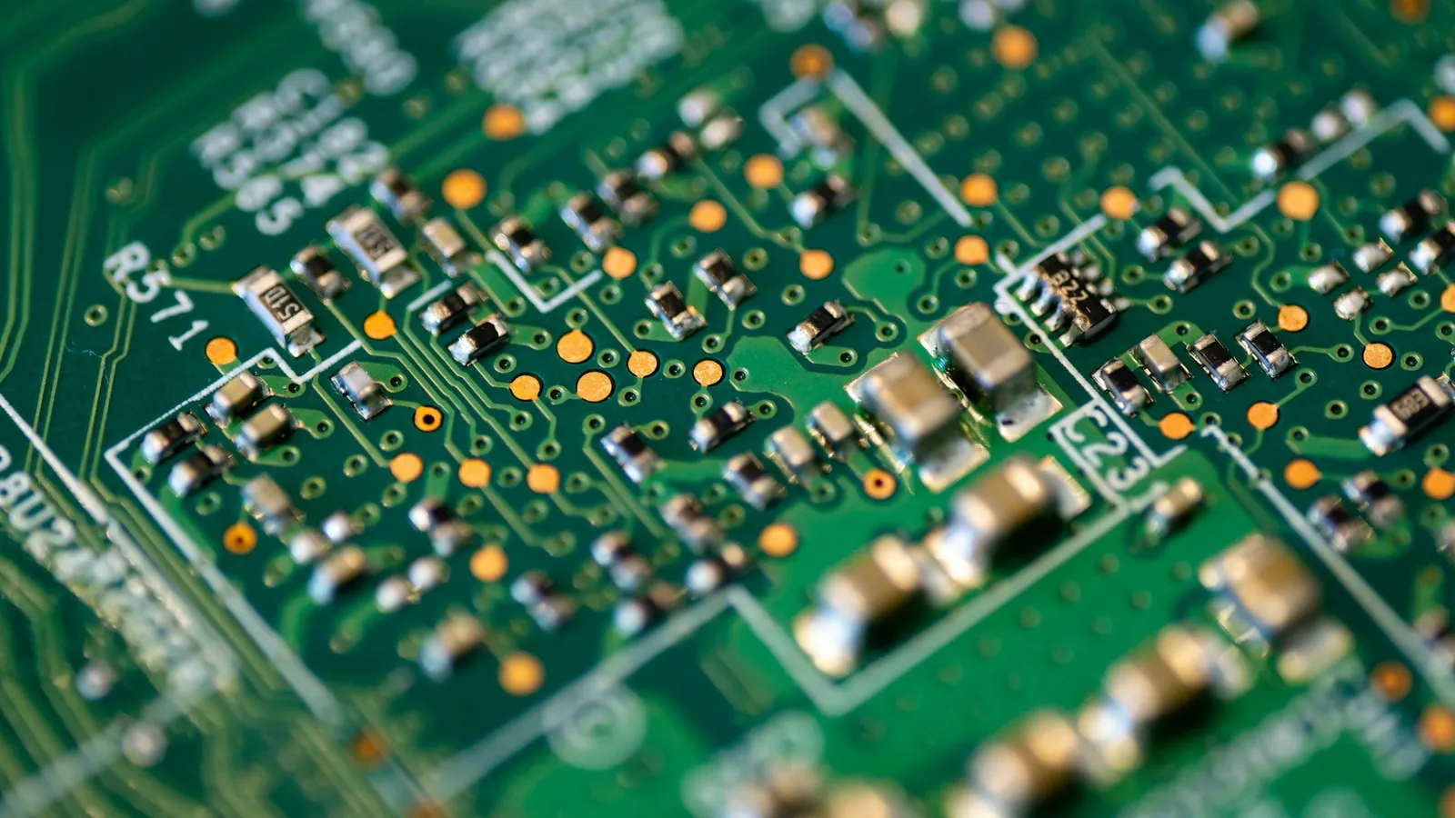 A green circuit board covered in small electronic components
