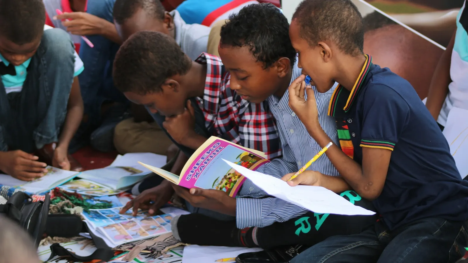 A group of children reading books together on the floor