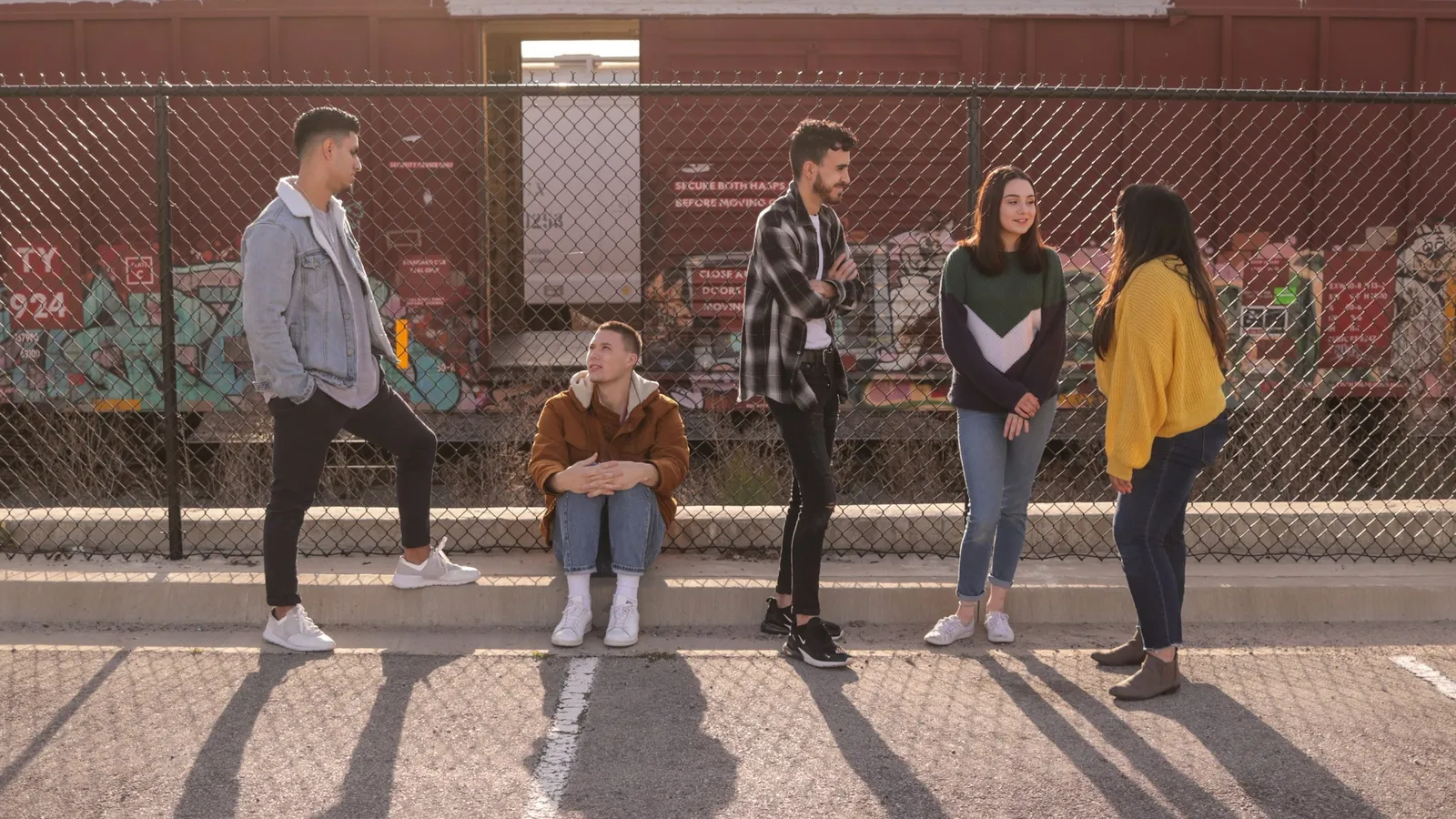 A group of teenagers standing and talking outdoors