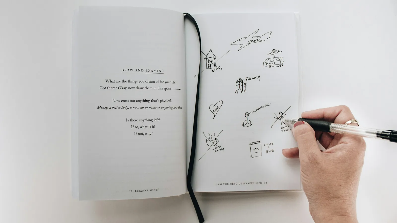 A hand drawing chemical structures in a notebook