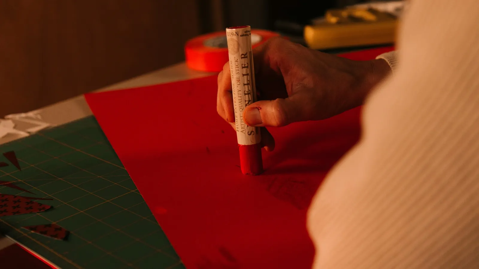 A hand marking a paper with a red pen