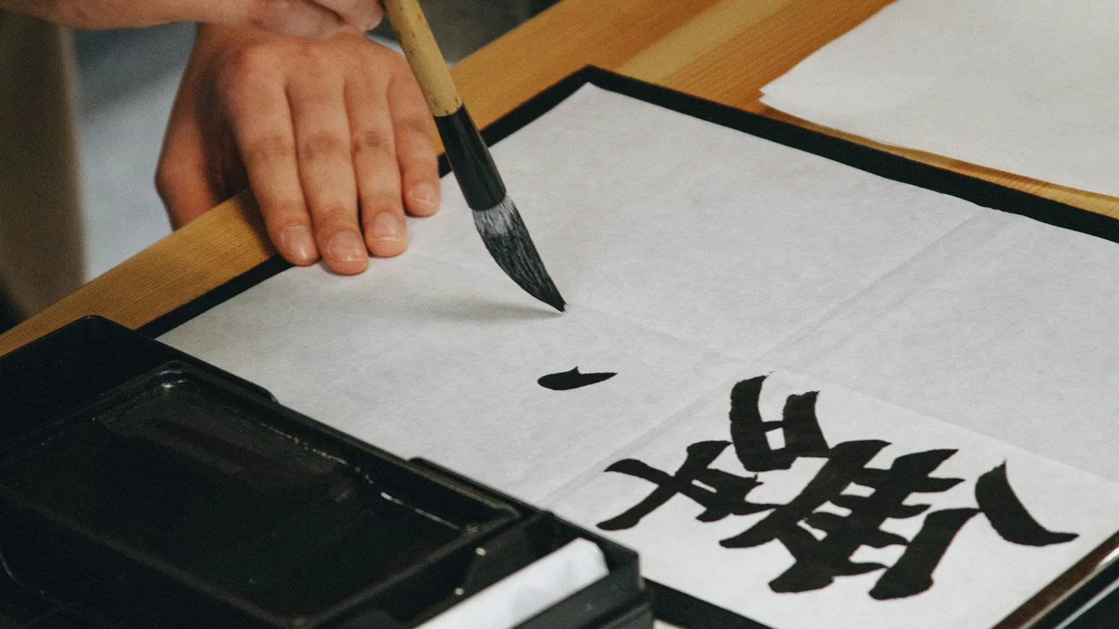 A hand writing Chinese characters with a brush
